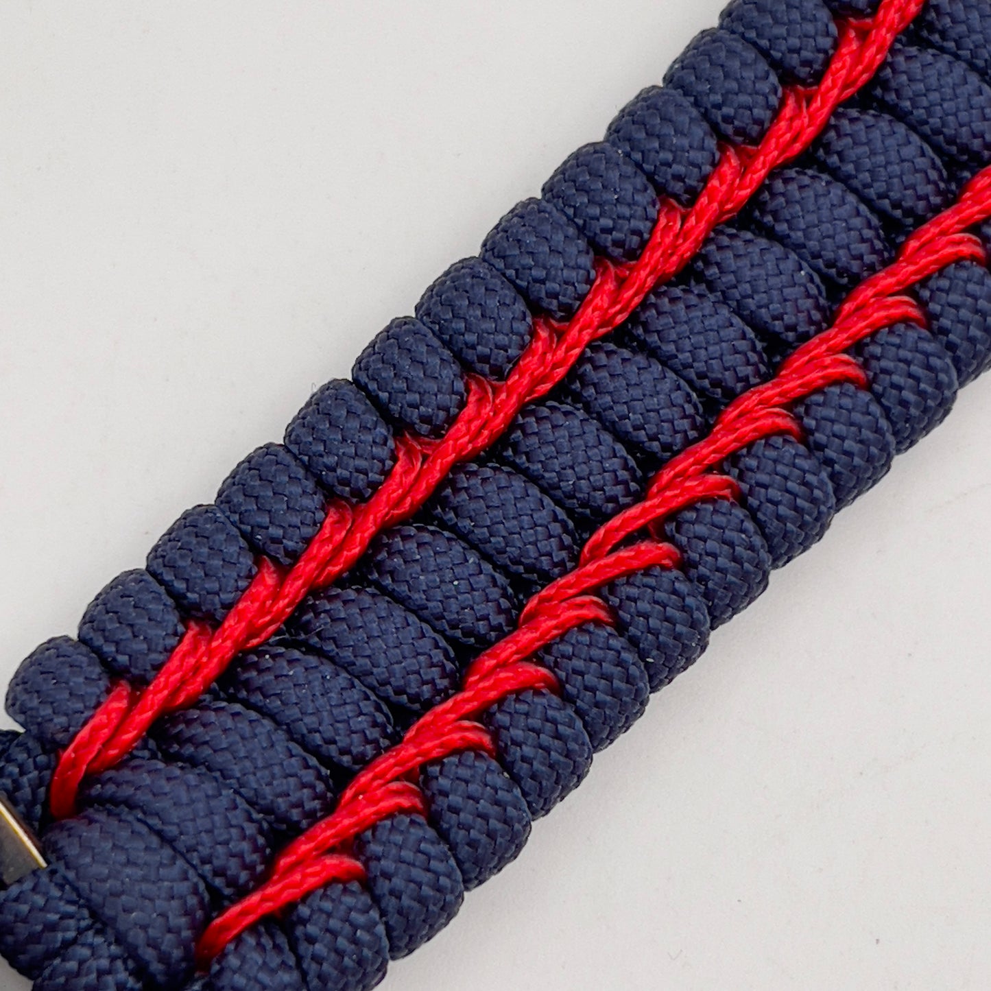 Thick and comfortable braided United States Marine Corps bracelet featuring a 24K gold and silver plated USMC officer Eagle Globe and Anchor medallion, a Cobra style tactical buckle and woven with gold 550 paracord and Imperial Red micro cord.