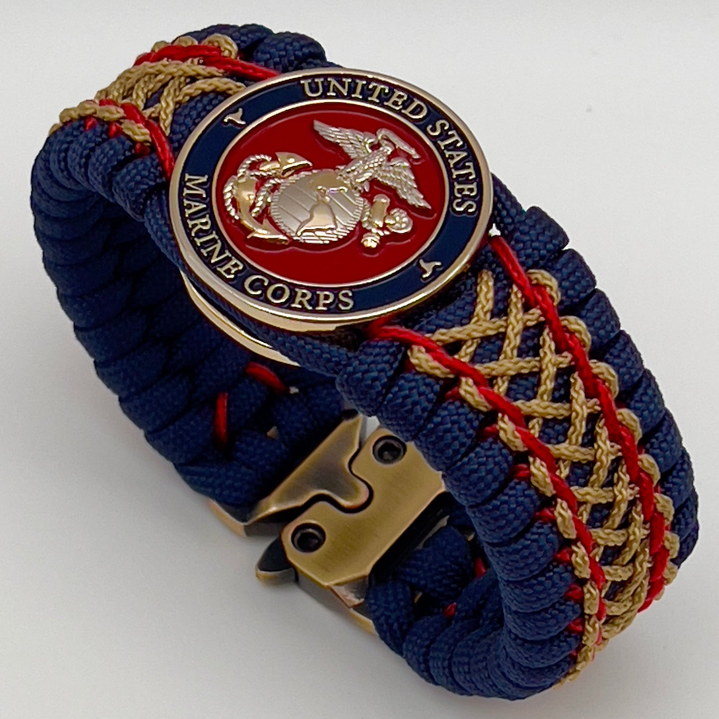 Thick and comfortable braided United States Marine Corps bracelet featuring a 24K gold and silver plated USMC officer Eagle Globe and Anchor medallion, a Cobra style tactical buckle and woven with gold 550 paracord and Imperial Red and Gold micro cord.