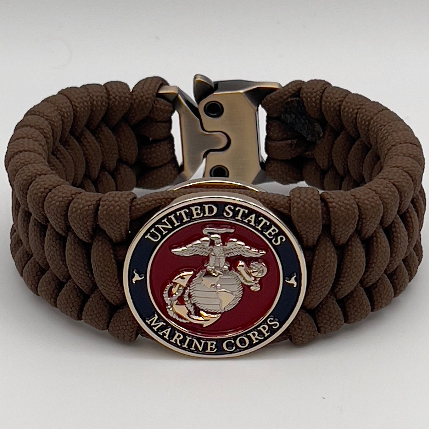 Thick and comfortable braided United States Marine Corps bracelet featuring a 24K gold and silver plated USMC officer Eagle Globe and Anchor medallion, a Cobra style tactical buckle and woven with Coyote Brown 550 paracord.