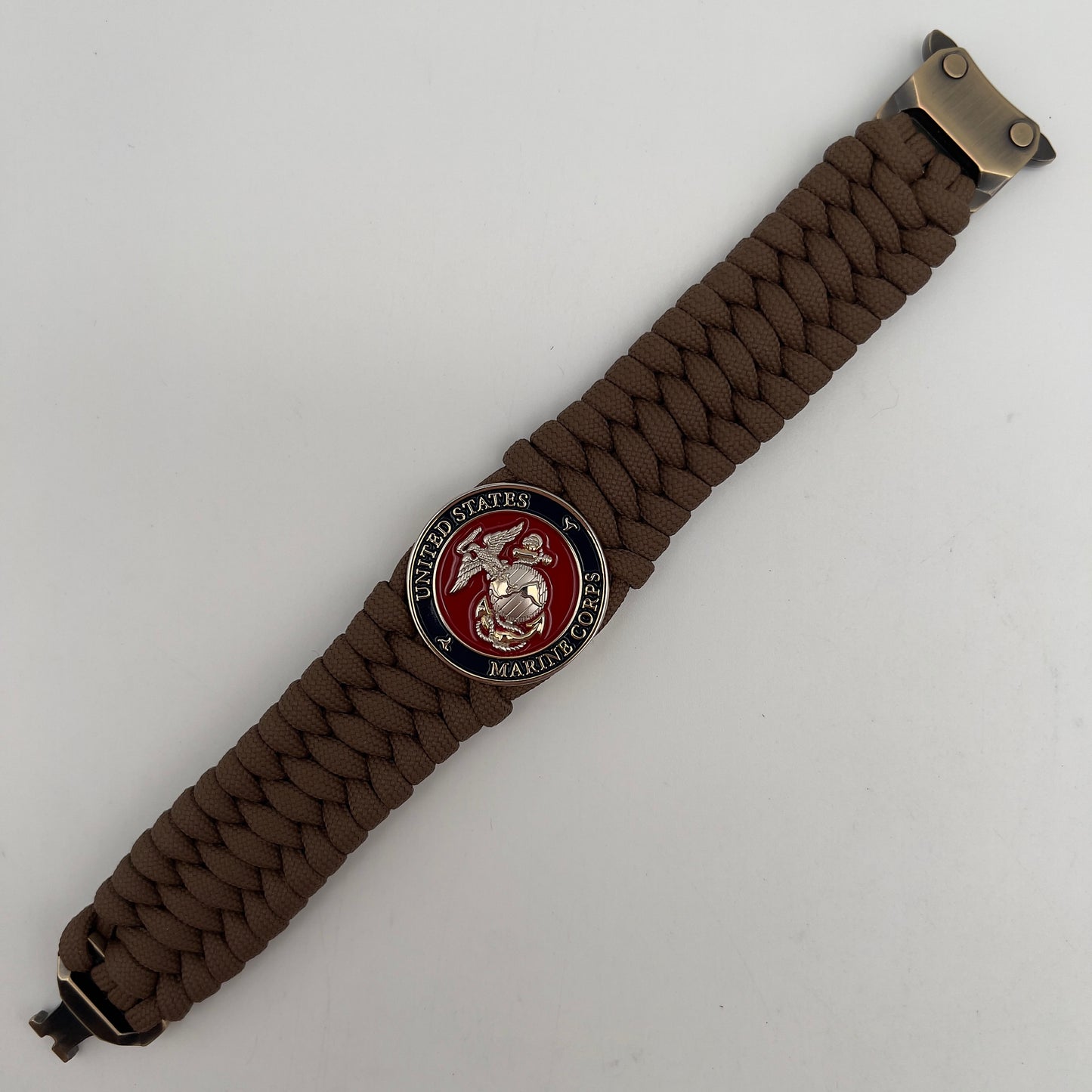 Thick and comfortable braided United States Marine Corps bracelet featuring a 24K gold and silver plated USMC officer Eagle Globe and Anchor medallion, a Cobra style tactical buckle and woven with Coyote Brown 550 paracord.