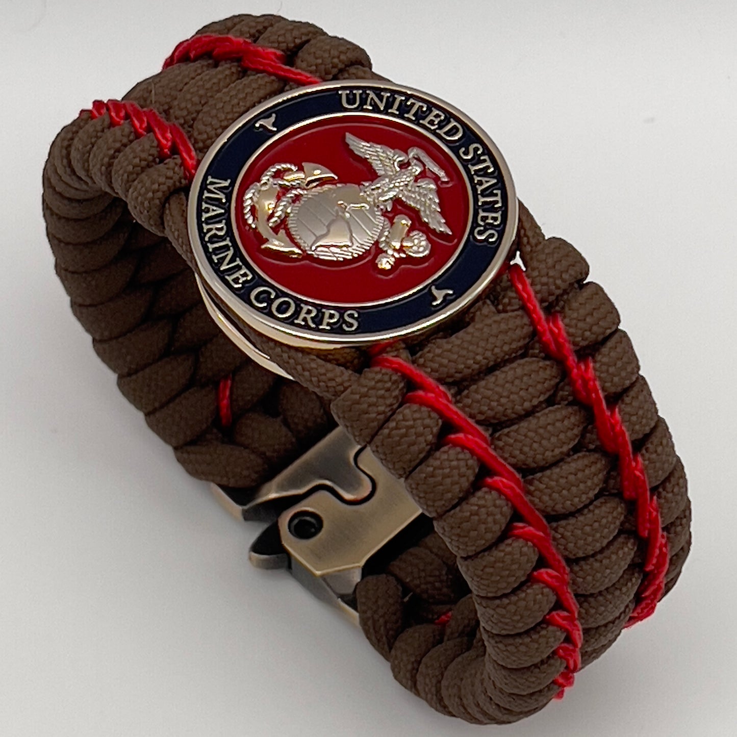 Thick and comfortable braided United States Marine Corps bracelet featuring a 24K gold and silver plated USMC officer Eagle Globe and Anchor medallion, a Cobra style tactical buckle and woven with Coyote Brown 550 paracord and Imperial Red micro cord.