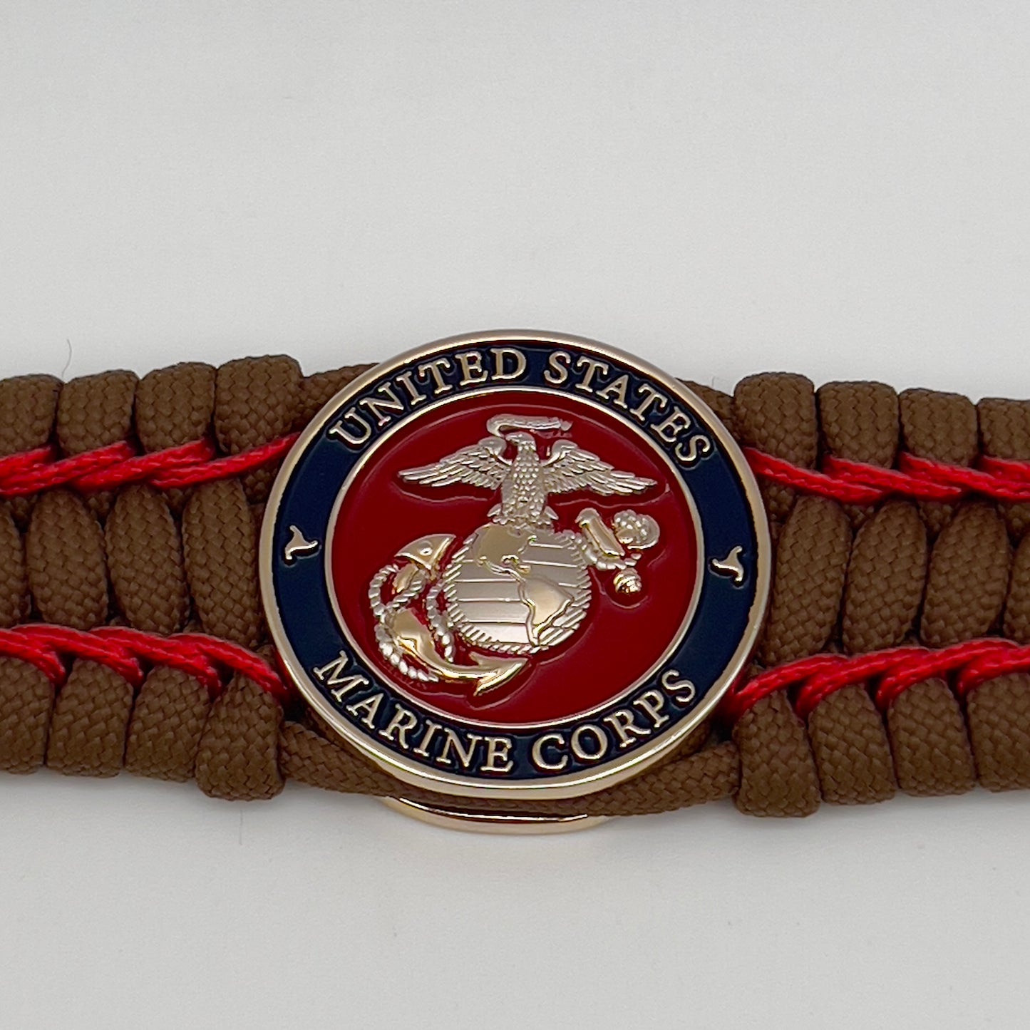 Thick and comfortable braided United States Marine Corps bracelet featuring a 24K gold and silver plated USMC officer Eagle Globe and Anchor medallion, a Cobra style tactical buckle and woven with Coyote Brown 550 paracord and Imperial Red micro cord.