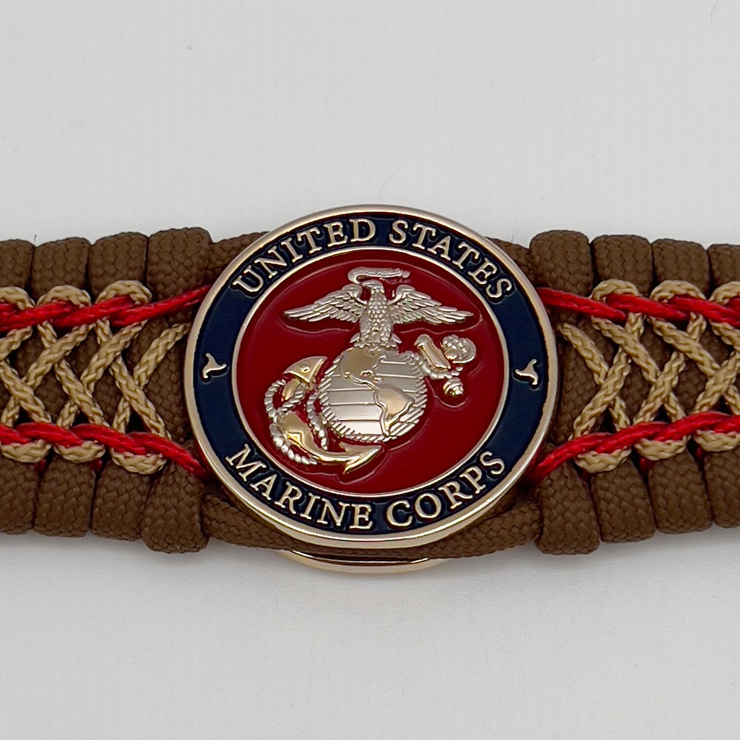 Thick and comfortable braided United States Marine Corps bracelet featuring a 24K gold and silver plated USMC officer Eagle Globe and Anchor medallion, a Cobra style tactical buckle and woven with Coyote Brown 550 paracord and Imperial Red and gold micro cord.