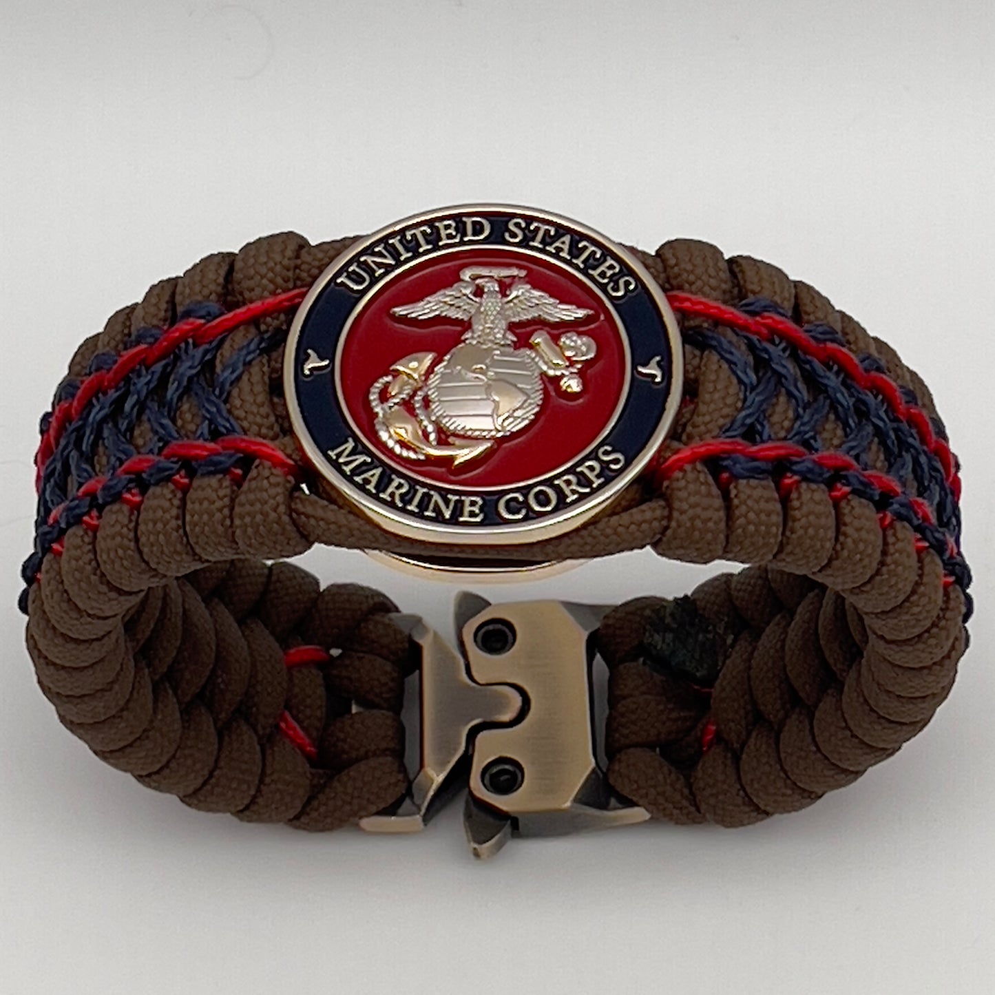 Thick and comfortable braided United States Marine Corps bracelet featuring a 24K gold and silver plated USMC officer Eagle Globe and Anchor medallion, a Cobra style tactical buckle and woven with Coyote Brown 550 paracord and Imperial Red and Navy Blue micro cord.