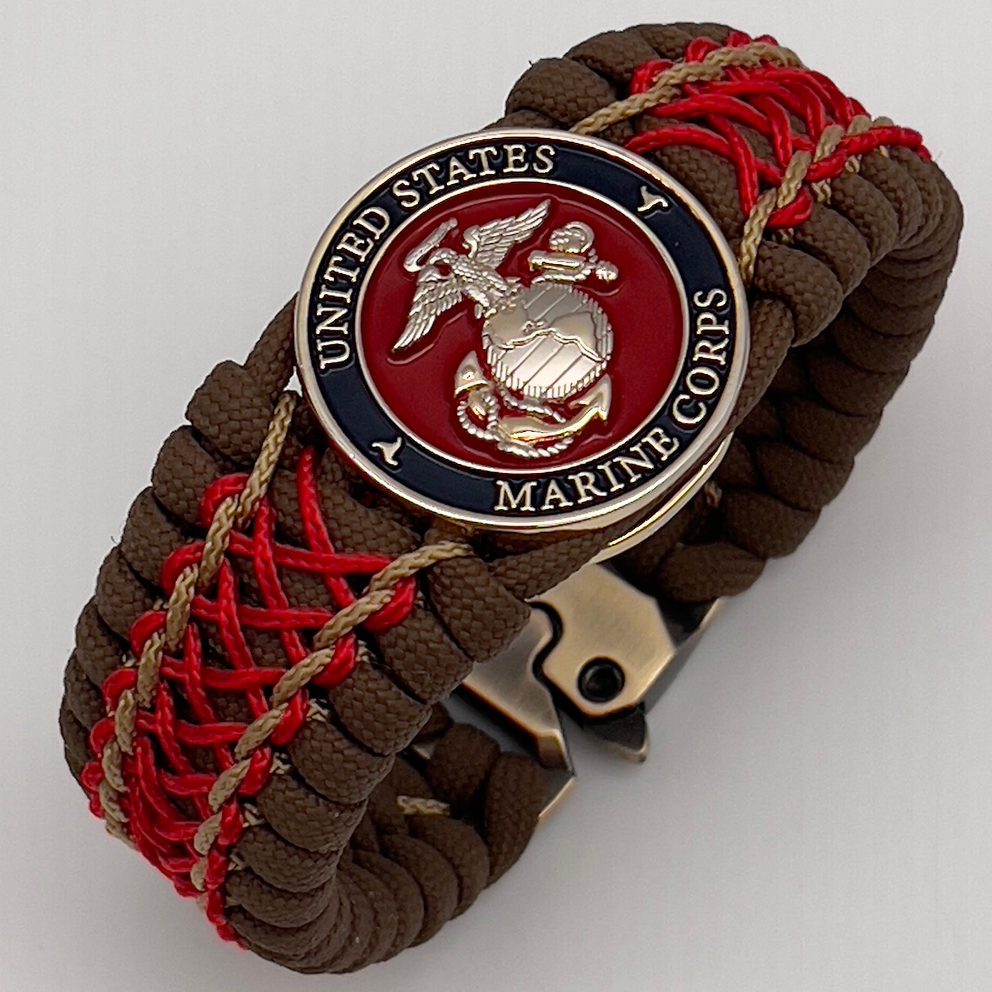 Thick and comfortable braided United States Marine Corps bracelet featuring a 24K gold and silver plated USMC officer Eagle Globe and Anchor medallion, a Cobra style tactical buckle and woven with Coyote Brown 550 paracord and Imperial Red and gold micro cord.