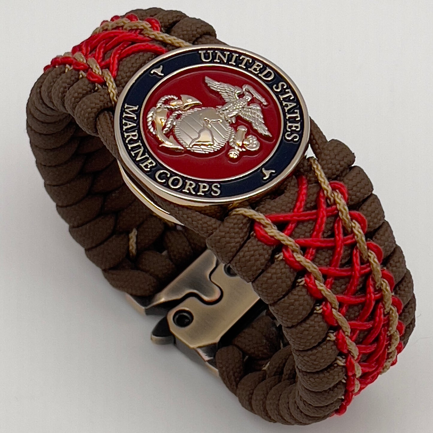 Thick and comfortable braided United States Marine Corps bracelet featuring a 24K gold and silver plated USMC officer Eagle Globe and Anchor medallion, a Cobra style tactical buckle and woven with Coyote Brown 550 paracord and Imperial Red and gold micro cord.