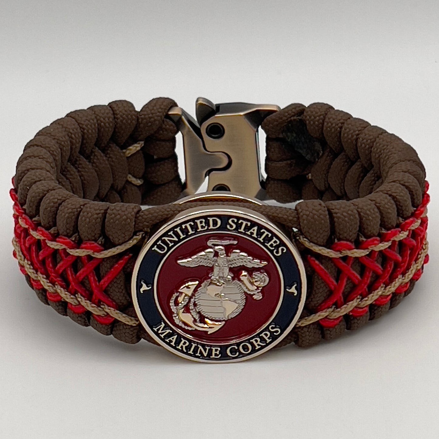 Thick and comfortable braided United States Marine Corps bracelet featuring a 24K gold and silver plated USMC officer Eagle Globe and Anchor medallion, a Cobra style tactical buckle and woven with Coyote Brown 550 paracord and Imperial Red and gold micro cord.