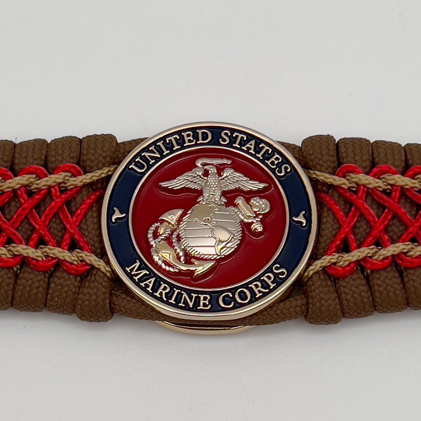 Thick and comfortable braided United States Marine Corps bracelet featuring a 24K gold and silver plated USMC officer Eagle Globe and Anchor medallion, a Cobra style tactical buckle and woven with Coyote Brown 550 paracord and Imperial Red and gold micro cord.