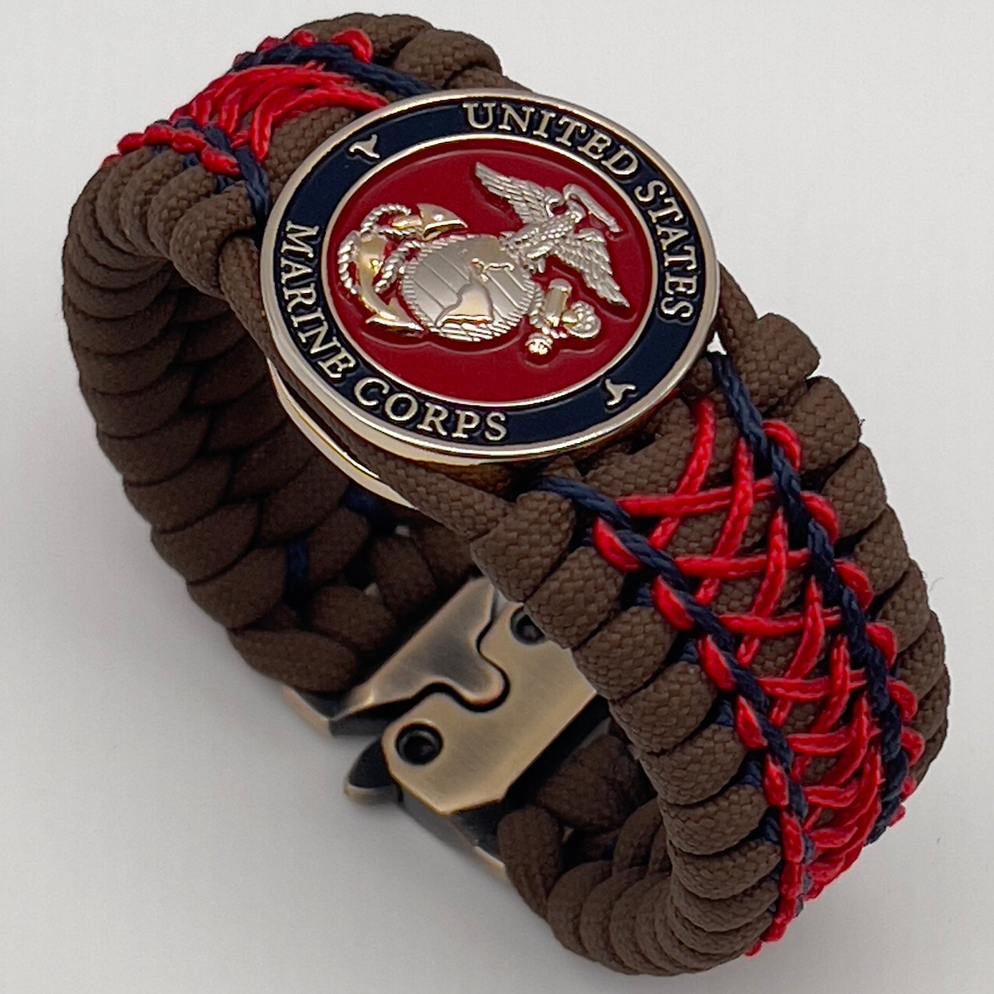 Thick and comfortable braided United States Marine Corps bracelet featuring a 24K gold and silver plated USMC officer Eagle Globe and Anchor medallion, a Cobra style tactical buckle and woven with Coyote Brown 550 paracord and Imperial Red and Navy Blue micro cord.