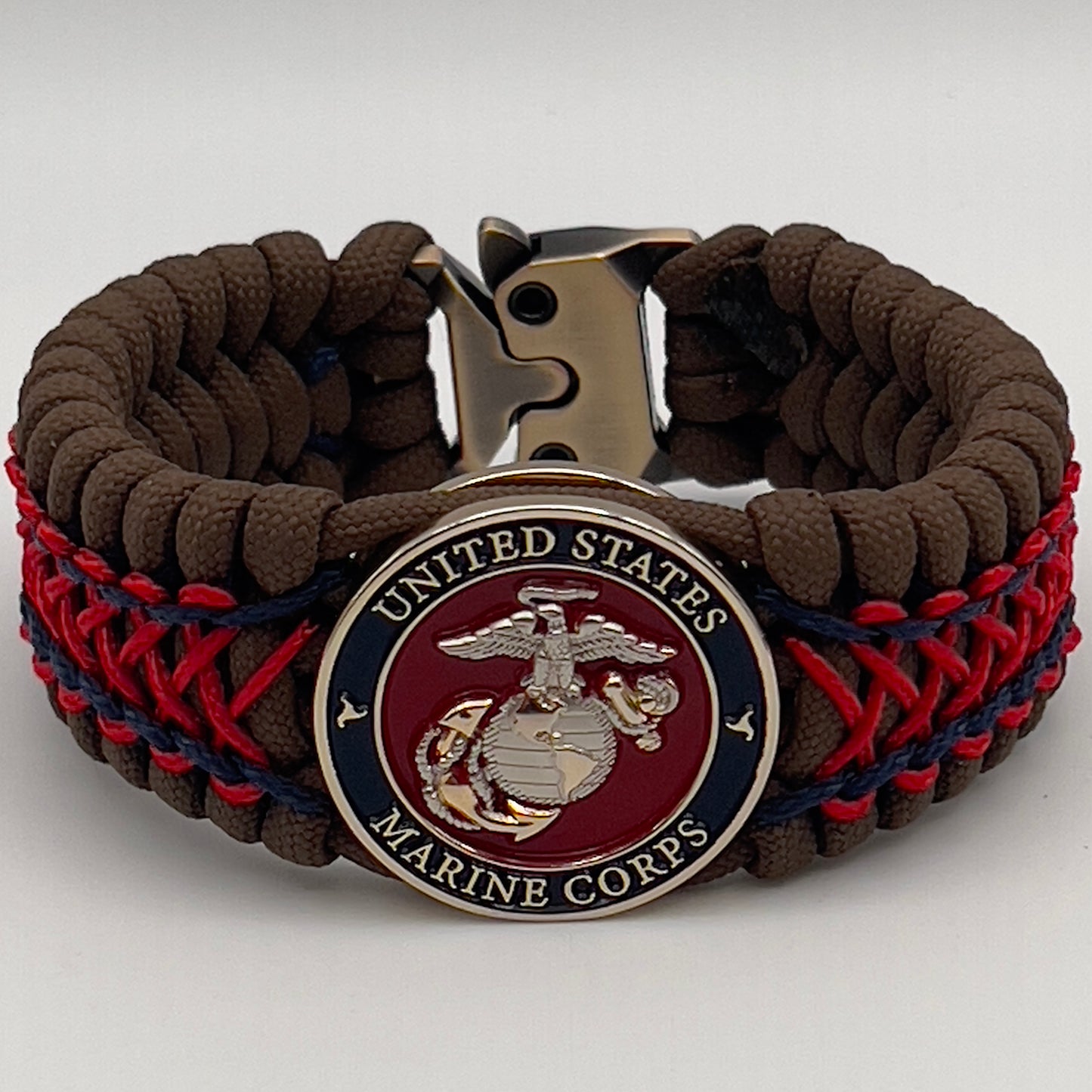 Thick and comfortable braided United States Marine Corps bracelet featuring a 24K gold and silver plated USMC officer Eagle Globe and Anchor medallion, a Cobra style tactical buckle and woven with Coyote Brown 550 paracord and Imperial Red and Navy Blue micro cord.