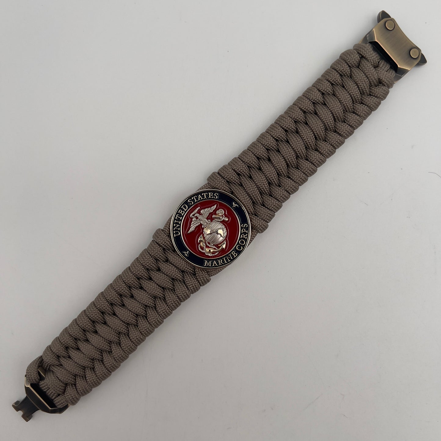 Thick and comfortable braided United States Marine Corps bracelet featuring a 24K gold and silver plated USMC officer Eagle Globe and Anchor medallion, a Cobra style tactical buckle and woven with tan 550 paracord.