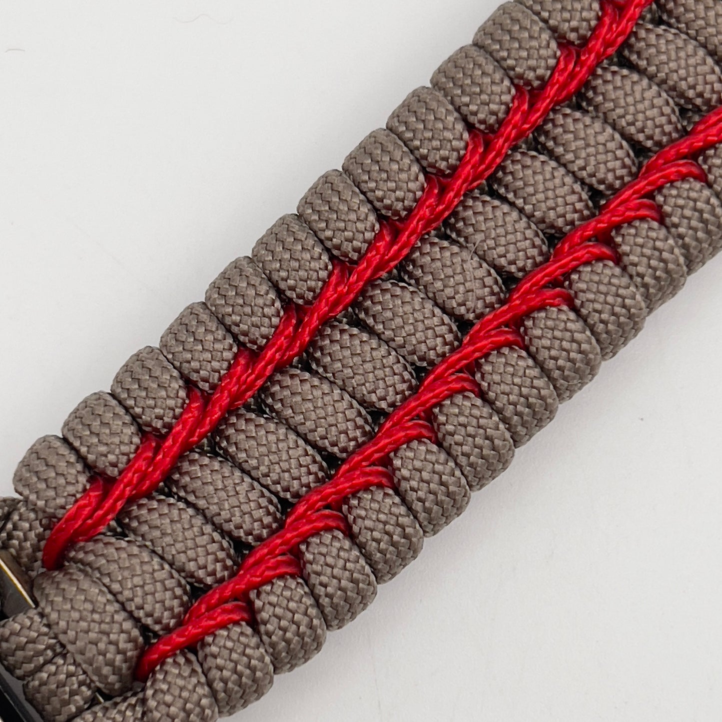 Thick, semi-rigid and comfortable braided United States Marine Corps bracelet featuring a 24K gold and silver plated USMC officer Eagle Globe and Anchor medallion, a gold Cobra style tactical buckle and woven with tan 550 paracord and Imperial Red micro cord.