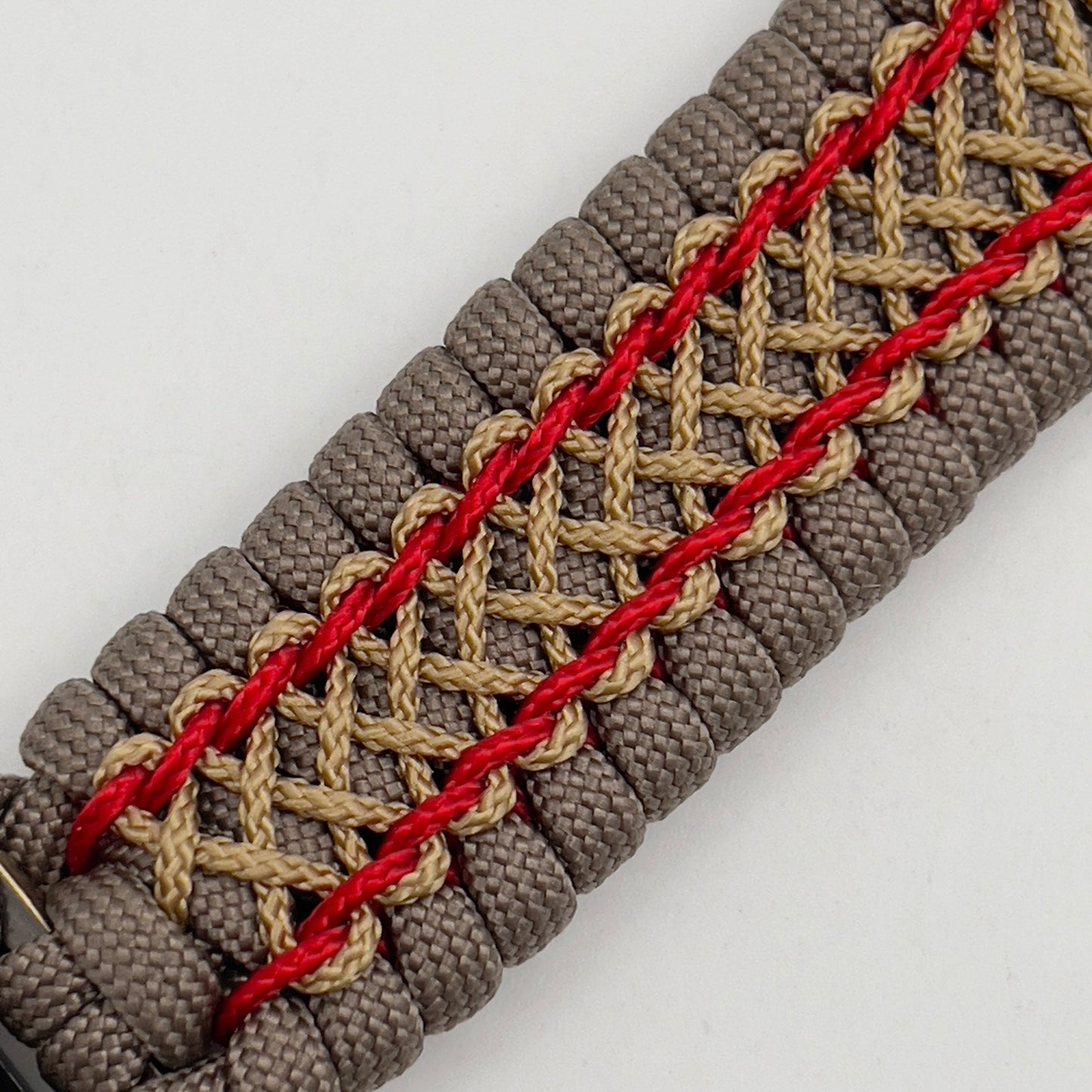 Thick, semi-rigid and comfortable braided United States Marine Corps bracelet featuring a 24K gold and silver plated USMC officer Eagle Globe and Anchor medallion, a gold Cobra style tactical buckle and woven with tan 550 paracord and Imperial Red and gold micro cord.