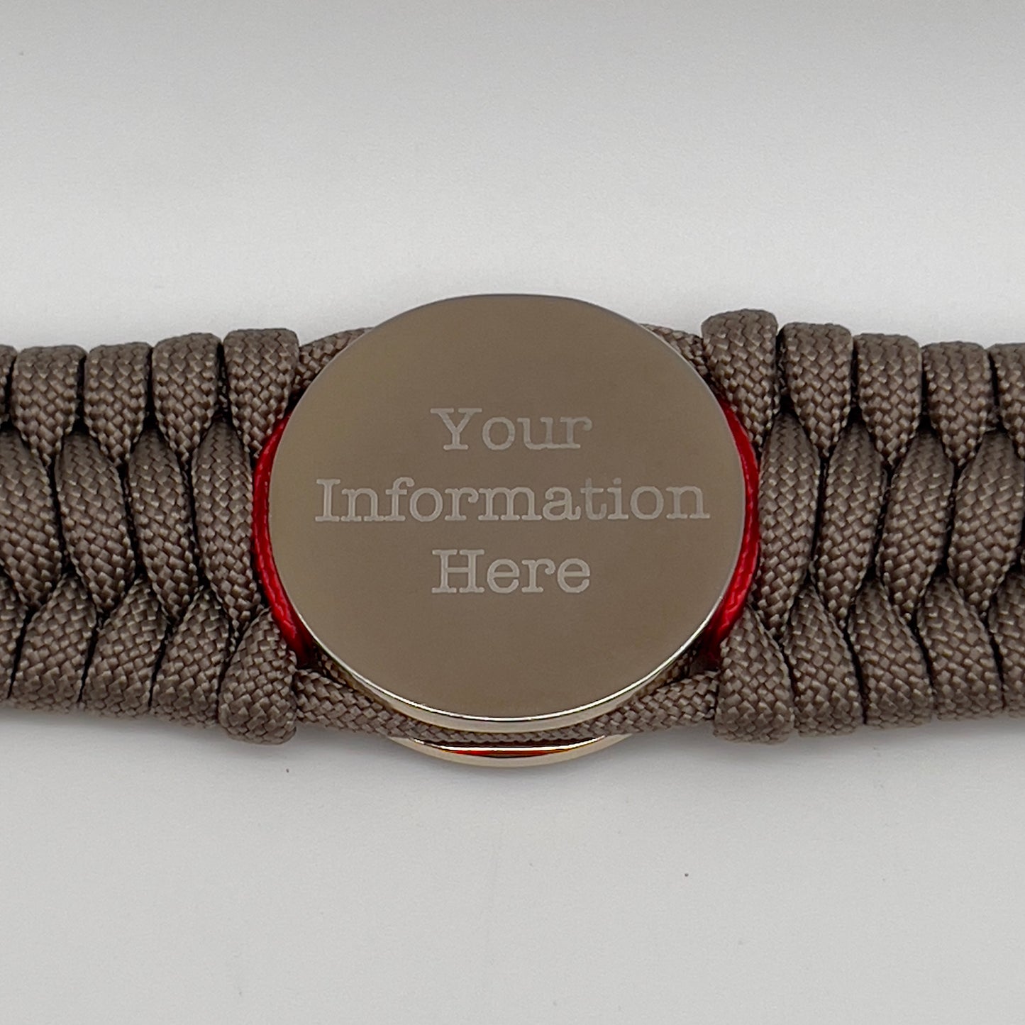 Thick, semi-rigid and comfortable braided United States Marine Corps bracelet featuring a 24K gold and silver plated USMC officer Eagle Globe and Anchor medallion, a gold Cobra style tactical buckle and woven with tan 550 paracord and Imperial Red and gold micro cord.