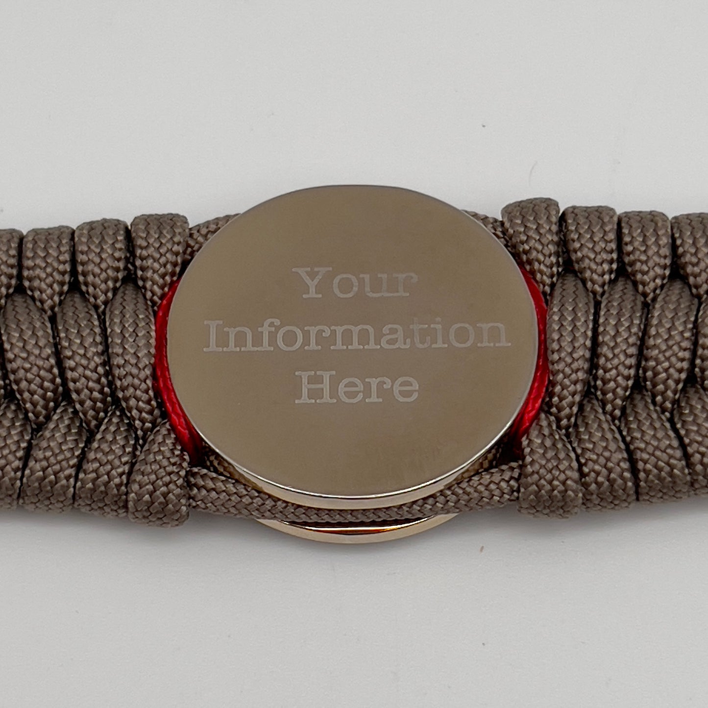 Thick, semi-rigid and comfortable braided United States Marine Corps bracelet featuring a 24K gold and silver plated USMC officer Eagle Globe and Anchor medallion, a gold Cobra style tactical buckle and woven with tan 550 paracord and Imperial red micro cord.