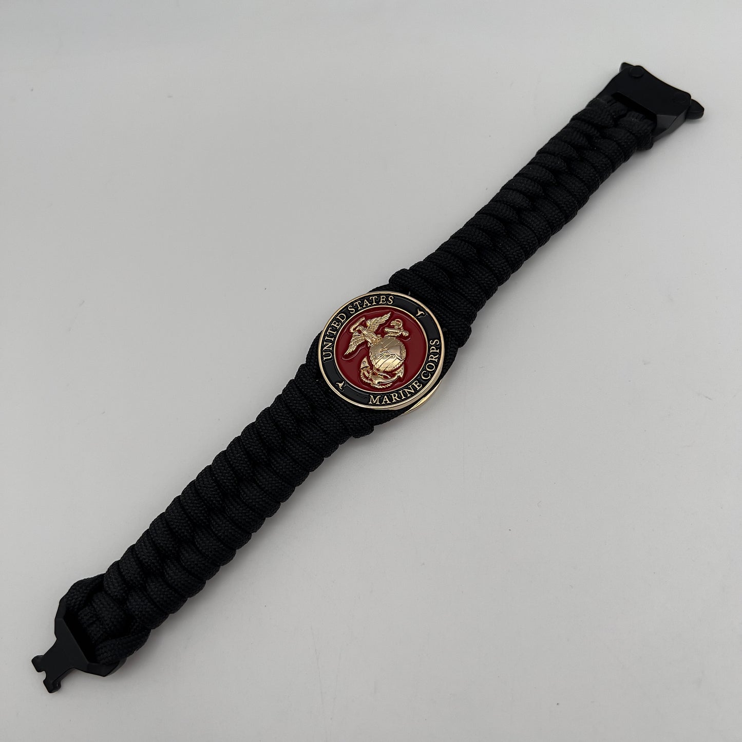 Thick, semi-rigid and comfortable braided United States Marine Corps bracelet featuring a 24K gold plated USMC officer Eagle Globe and Anchor medallion, a black Cobra style tactical buckle and woven with black 550 paracord.