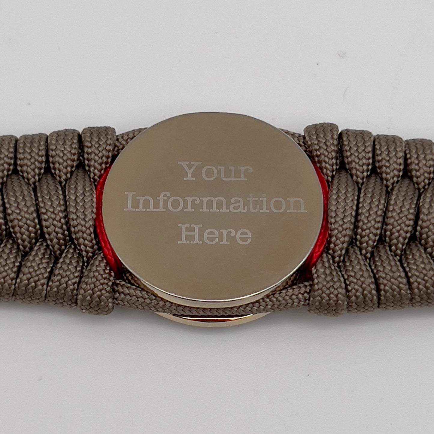 Thick, rigid and comfortable braided United States Marine Corps bracelet featuring a 24K gold and silver plated USMC officer Eagle Globe and Anchor medallion, a gold Cobra style tactical buckle and woven with tan 550 paracord and Imperial Red and Navy Blue micro cord.