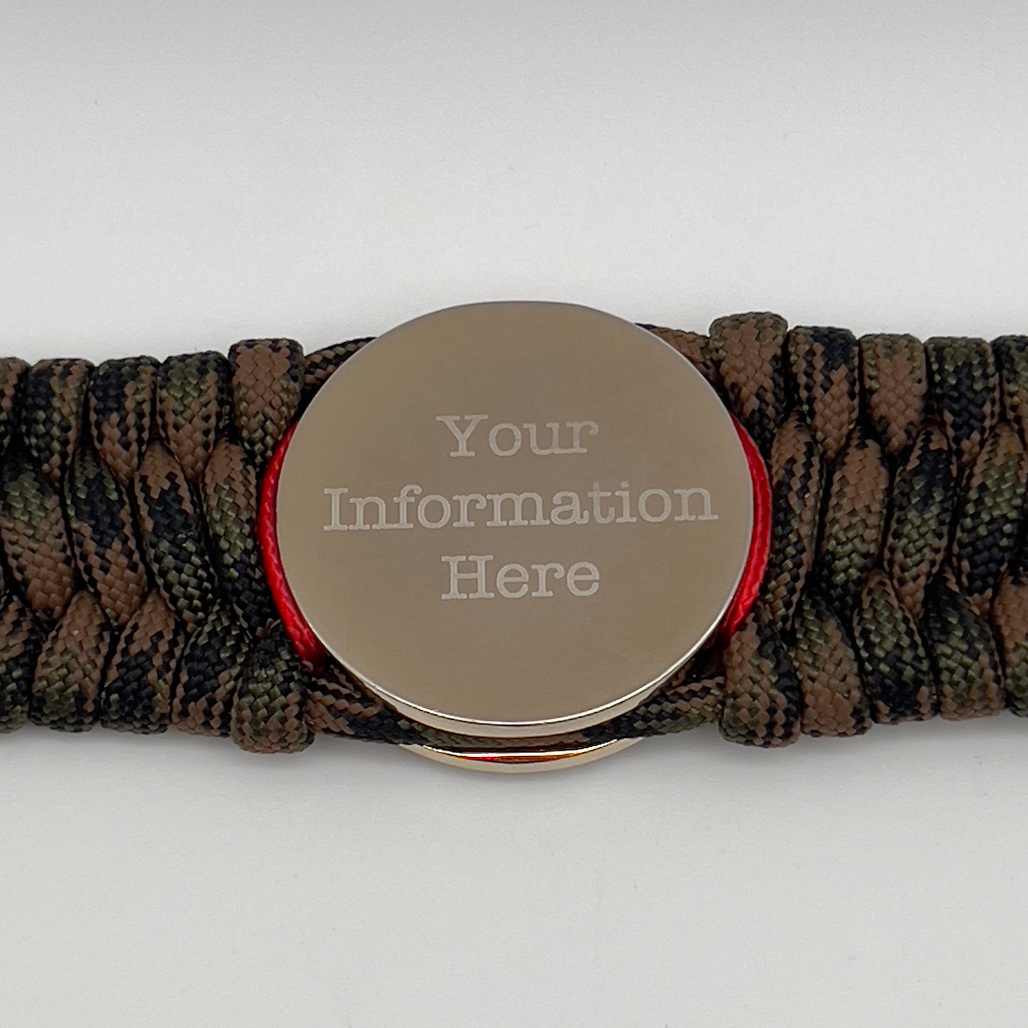 Thick, rigid and comfortable braided United States Marine Corps bracelet featuring a 24K gold and silver plated USMC officer Eagle Globe and Anchor medallion, a gold Cobra style tactical buckle and woven with Woodland Camo 550 paracord and Imperial Red micro cord.