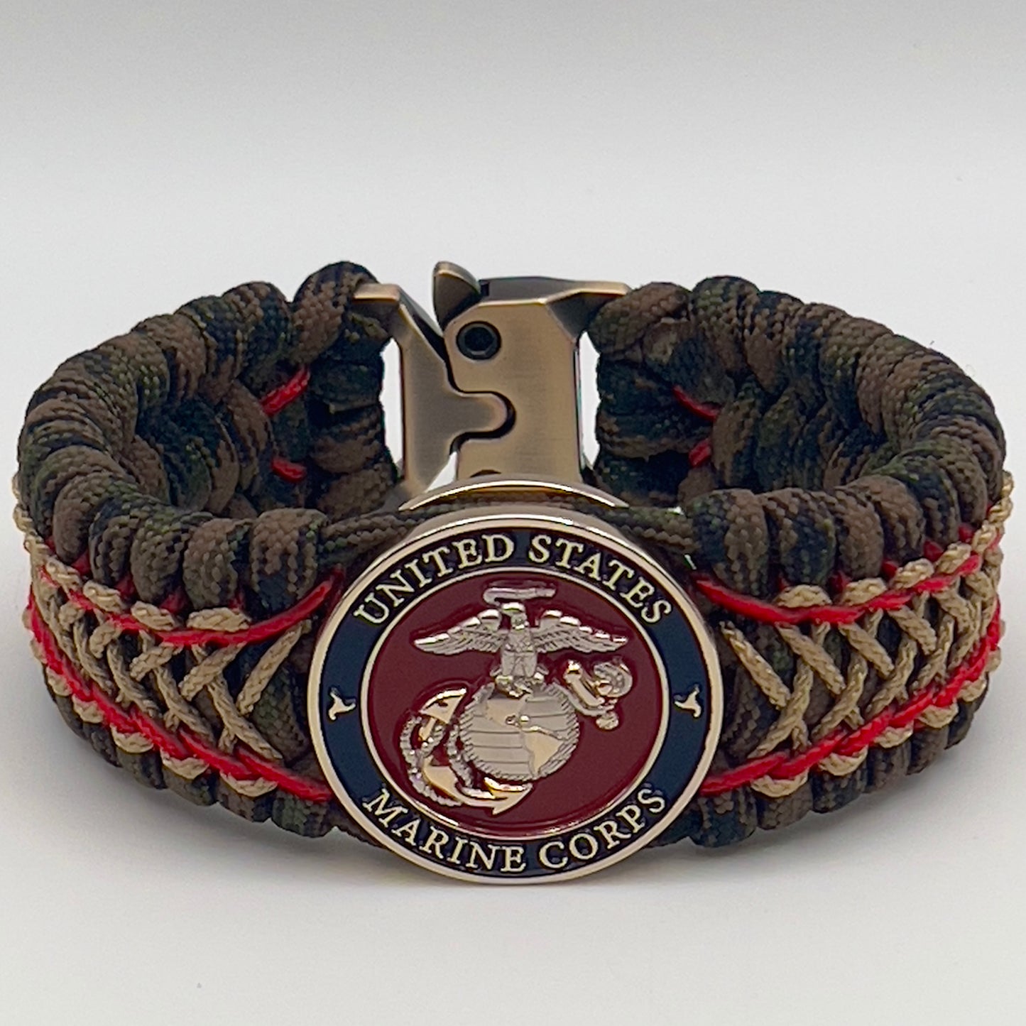 Thick, rigid and comfortable braided United States Marine Corps bracelet featuring a 24K gold and silver plated USMC officer Eagle Globe and Anchor medallion, a gold Cobra style tactical buckle and woven with Woodland Camo 550 paracord and Imperial Red and gold micro cord.