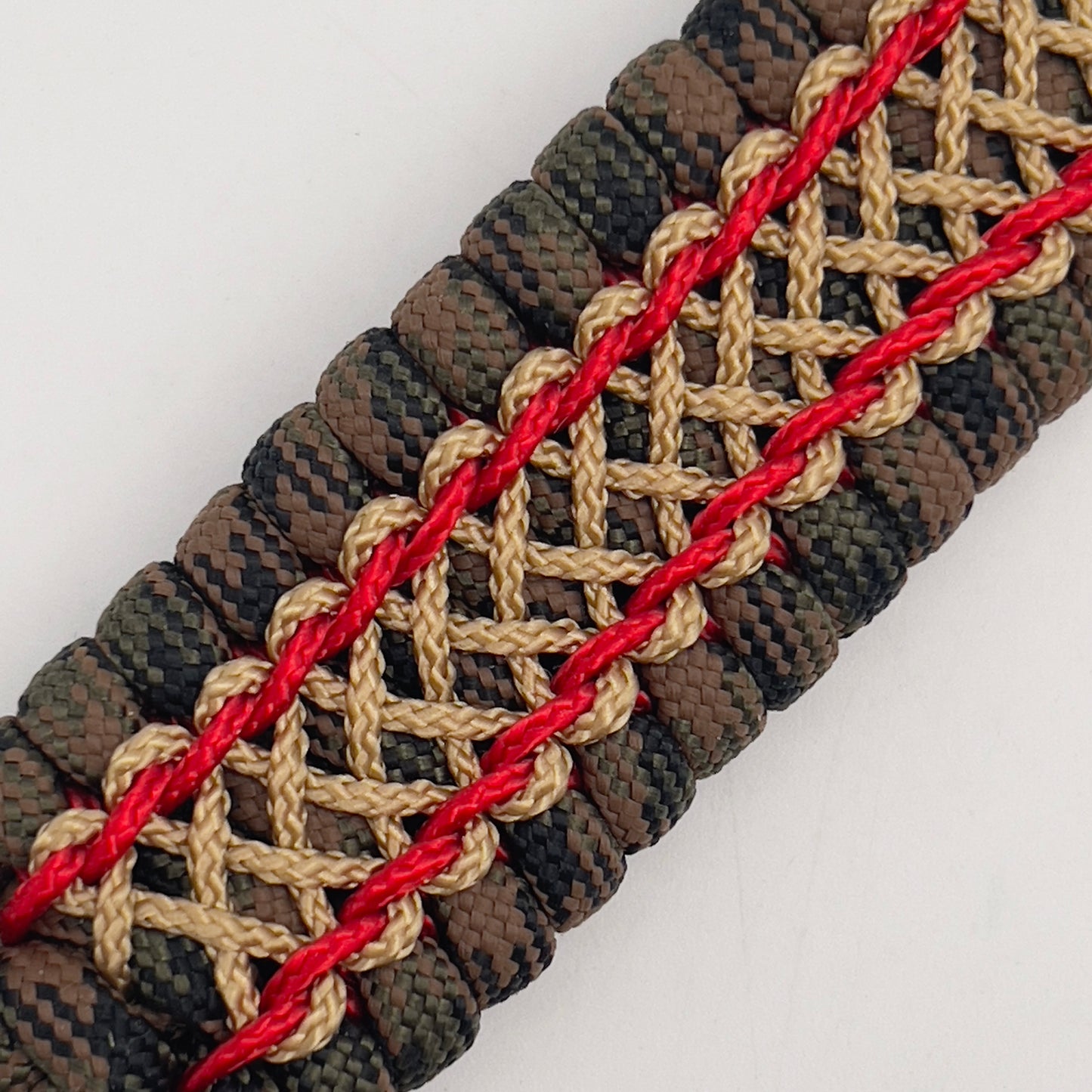 Thick, rigid and comfortable braided United States Marine Corps bracelet featuring a 24K gold and silver plated USMC officer Eagle Globe and Anchor medallion, a gold Cobra style tactical buckle and woven with Woodland Camo 550 paracord and Imperial Red and gold micro cord.