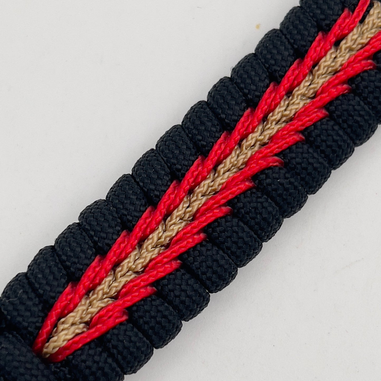 Thick, semi-rigid and comfortable braided United States Marine Corps bracelet featuring a 24K gold and silver plated USMC officer Eagle Globe and Anchor medallion, a black Cobra style tactical buckle and woven with black 550, Imperial red and gold micro paracord.