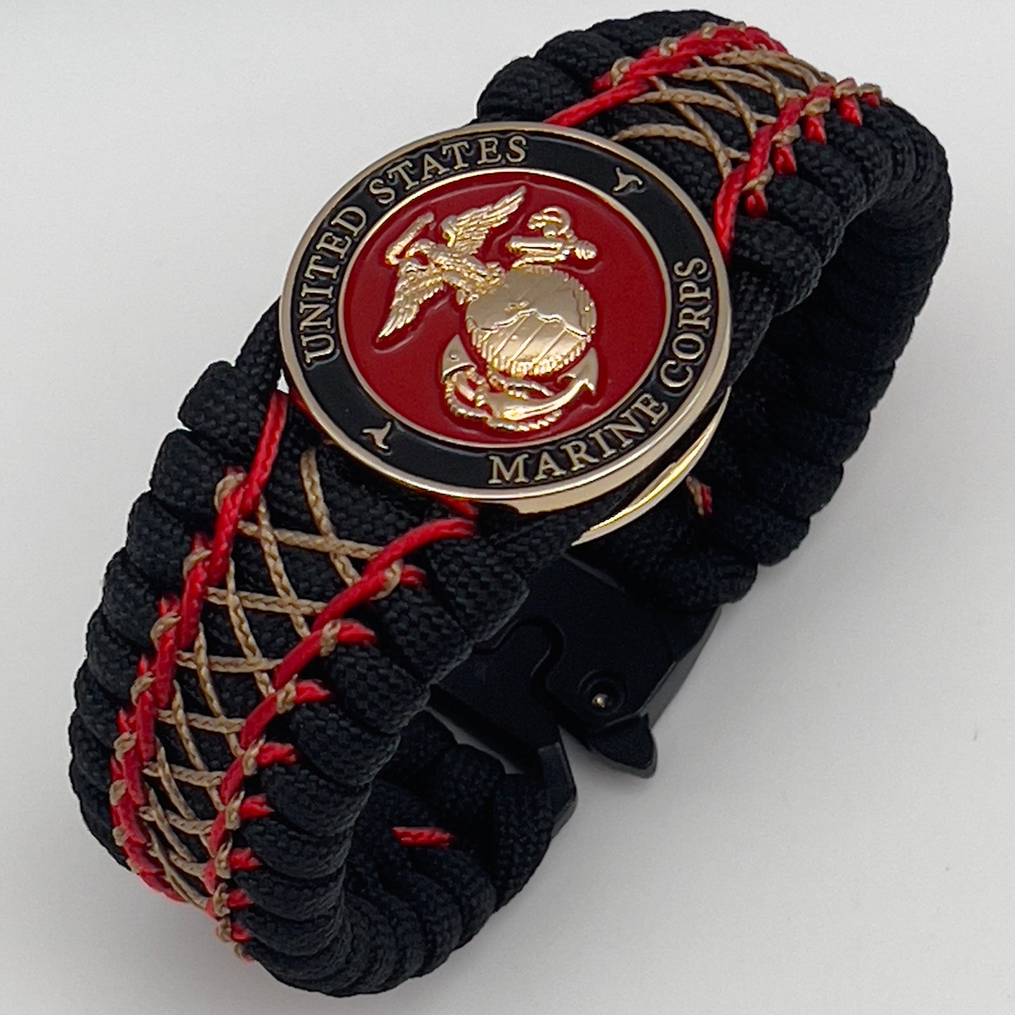 Thick, wide, rigid and comfortable braided United States Marine Corps bracelet featuring a 24K gold plated USMC Eagle Globe and Anchor medallion, a black Cobra style tactical buckle and woven with black 550 paracord and Imperial Red micro and gold nano cord.