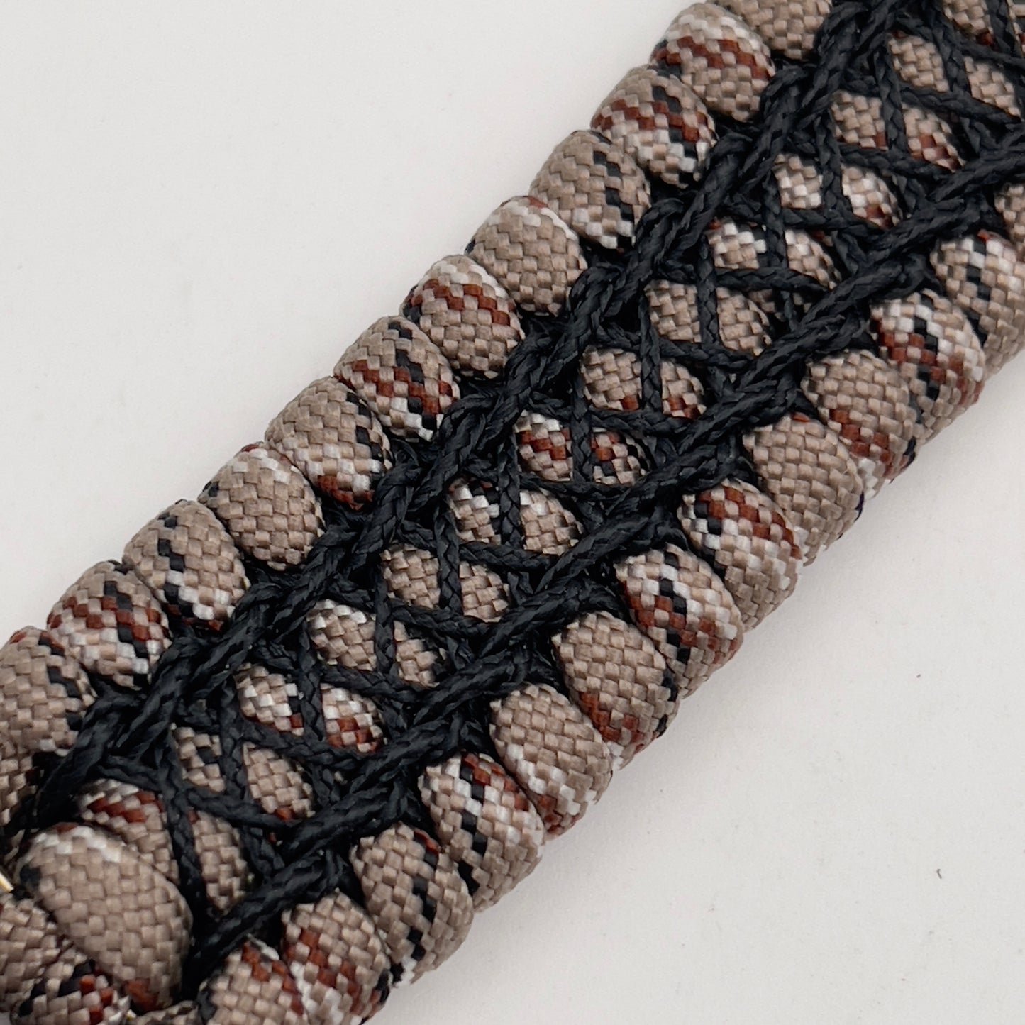 Thick, wide, rigid and comfortable braided United States Marine Corps bracelet featuring a 24K gold plated USMC Eagle Globe and Anchor medallion, a gold Cobra style tactical buckle and woven with Desert Camo 550 paracord and black nano and micro cord.