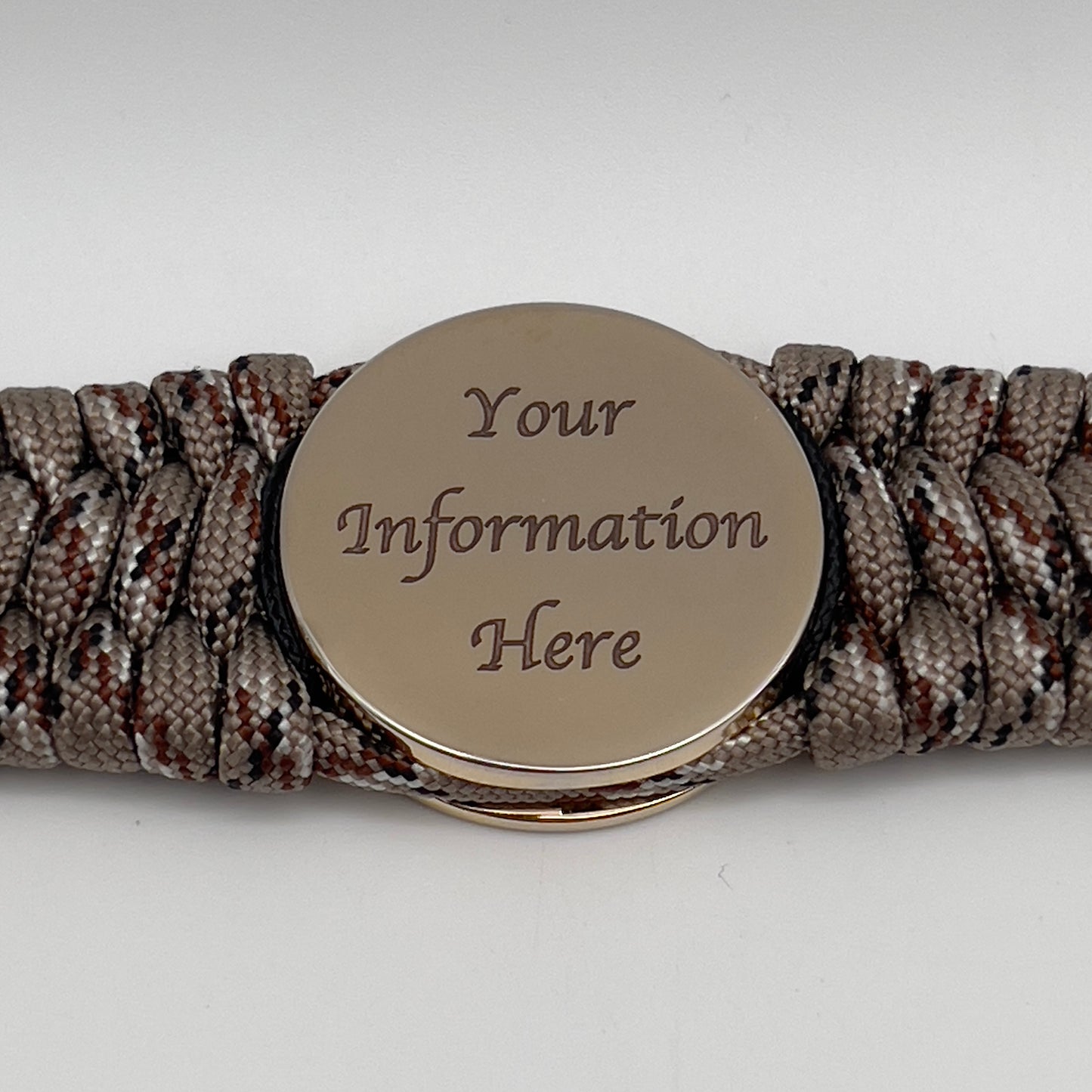 Thick, wide, rigid and comfortable braided United States Marine Corps bracelet featuring a 24K gold plated USMC Eagle Globe and Anchor medallion, a gold Cobra style tactical buckle and woven with Desert Camo 550 paracord and black nano and micro cord.