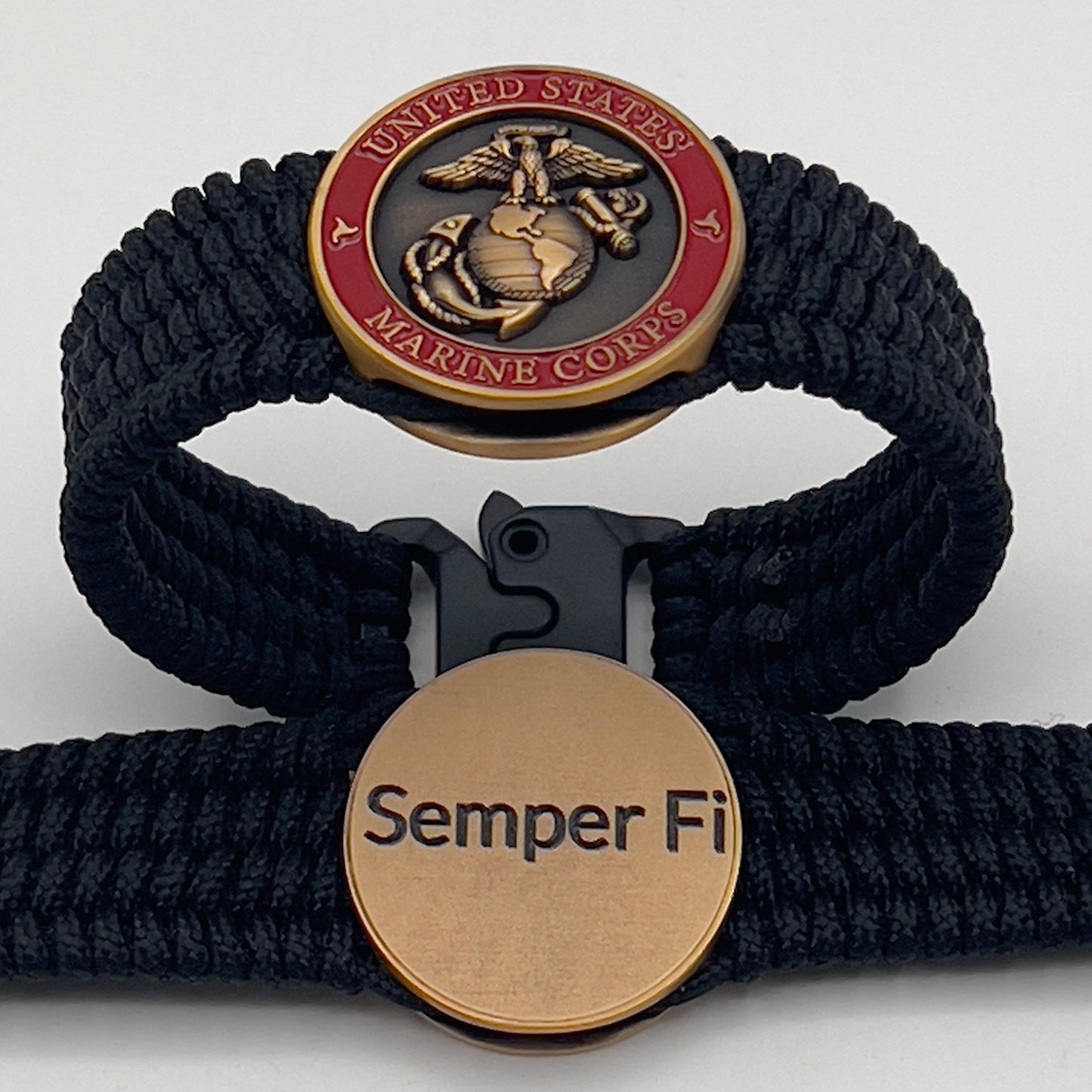 Thin, narrow, very flexible and comfortable braided United States Marine Corps bracelet featuring a 24K antique gold plated USMC Eagle Globe and Anchor medallion, a black Cobra style tactical buckle and woven with black Type-1 paracord.