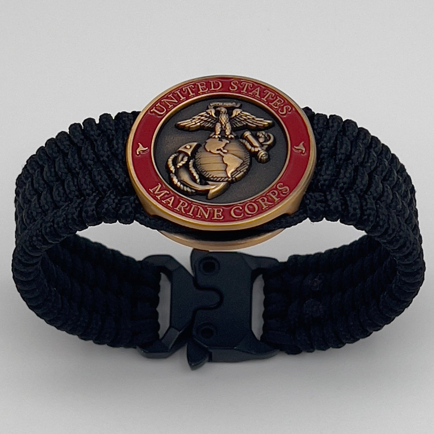 Thin, narrow, very flexible and comfortable braided United States Marine Corps bracelet featuring a 24K antique gold plated USMC Eagle Globe and Anchor medallion, a black Cobra style tactical buckle and woven with black Type-1 paracord.