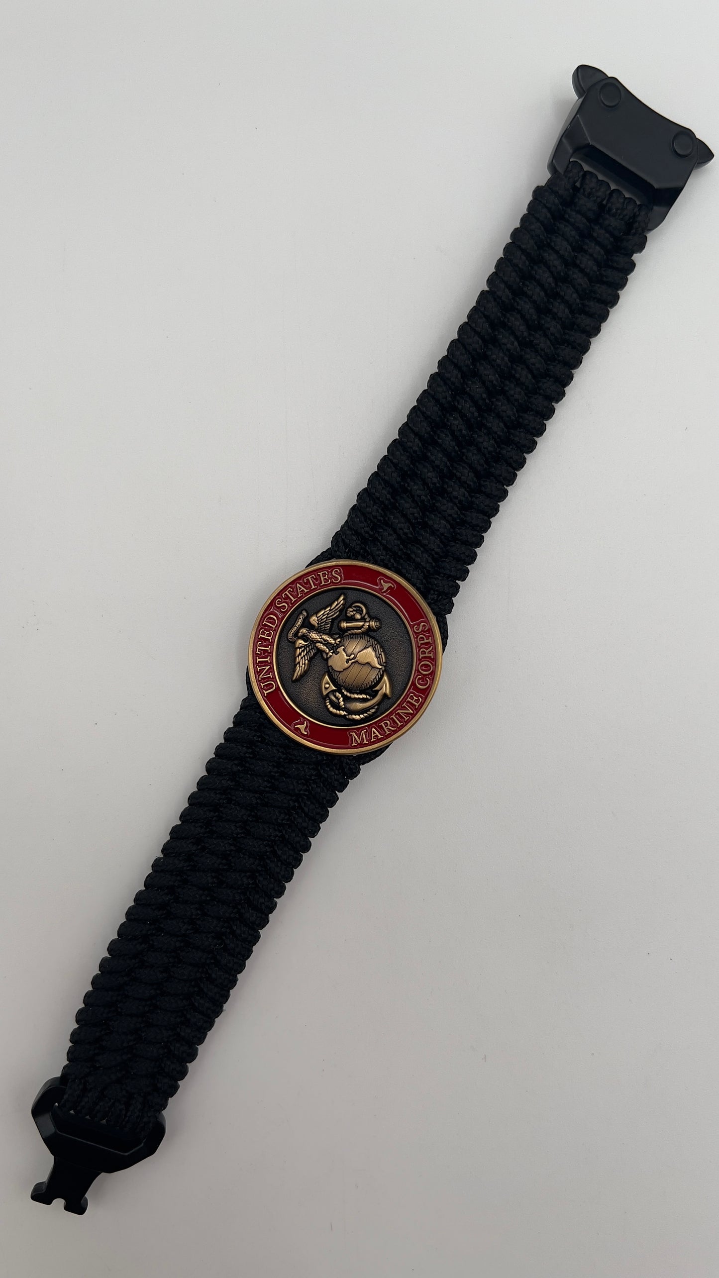 Thin, wide, very flexible and comfortable braided United States Marine Corps bracelet featuring a 24K antique gold plated USMC Eagle Globe and Anchor medallion engraved with the Punisher logo, a black Cobra style tactical buckle and woven with black Type-1 paracord.