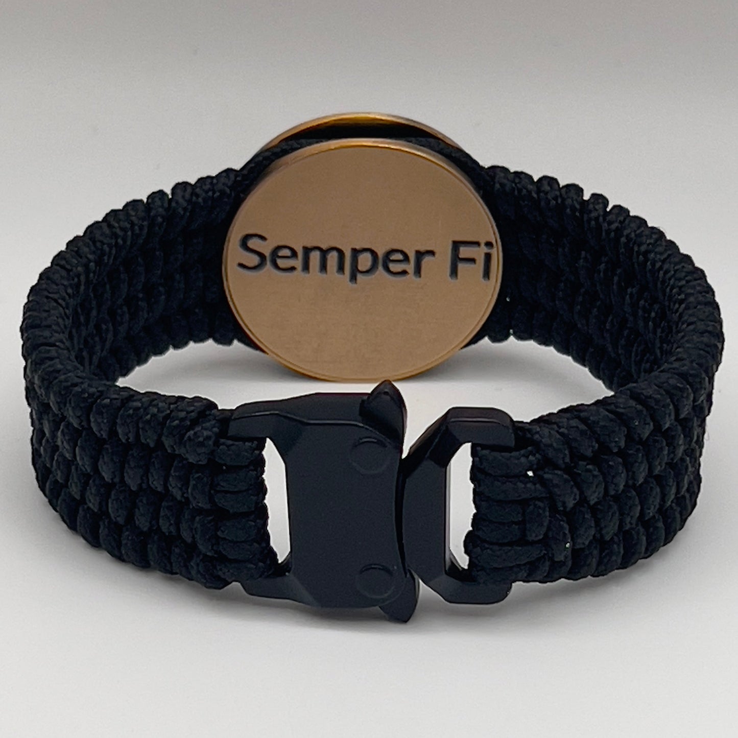 Thin, narrow, very flexible and comfortable braided United States Marine Corps bracelet featuring a 24K antique gold plated USMC Eagle Globe and Anchor medallion, a black Cobra style tactical buckle and woven with black Type-1 paracord.