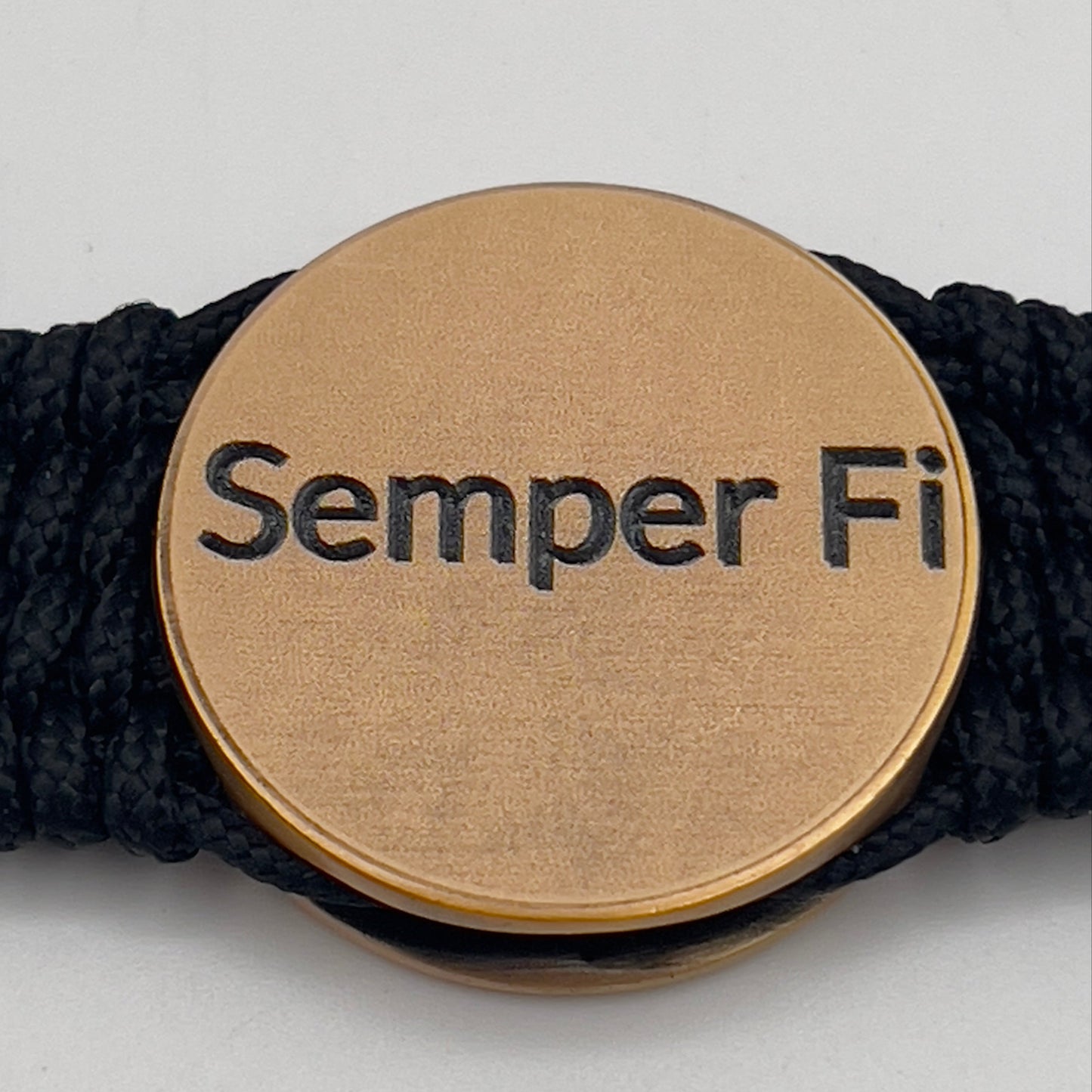 Thin, narrow, very flexible and comfortable braided United States Marine Corps bracelet featuring a 24K antique gold plated USMC Eagle Globe and Anchor medallion, a black Cobra style tactical buckle and woven with black Type-1 paracord.