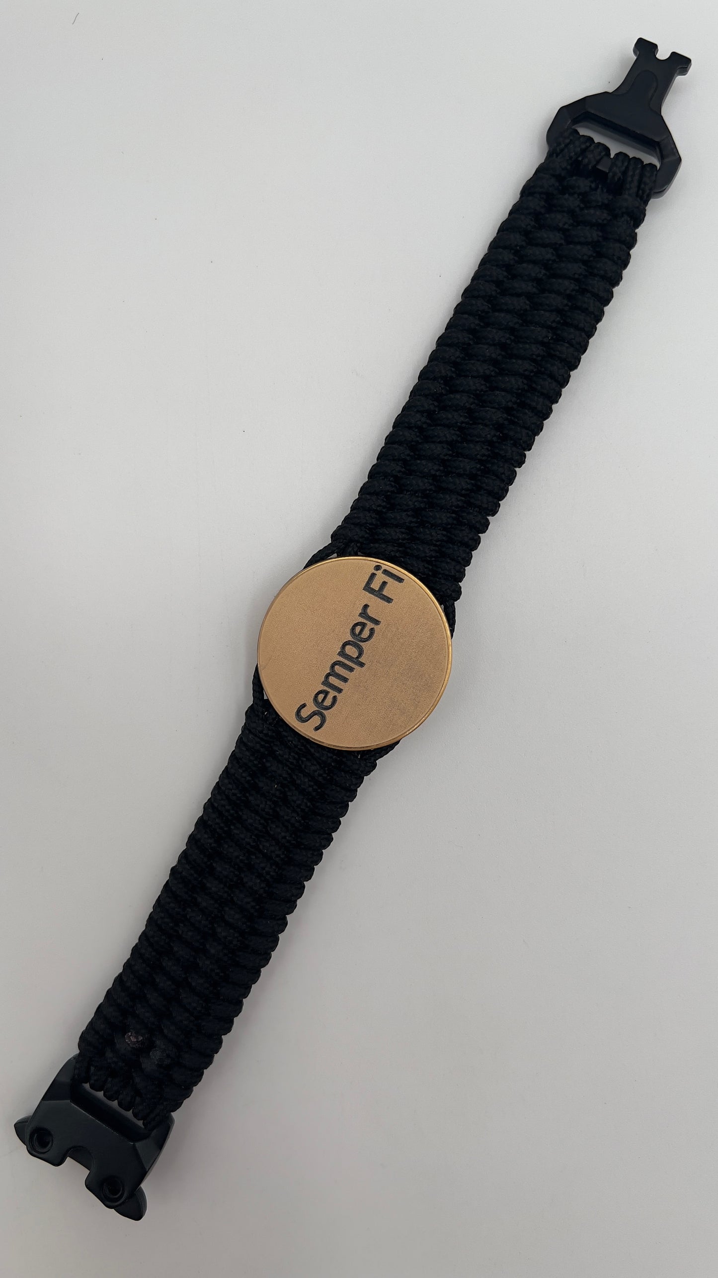 Thin, wide, very flexible and comfortable braided United States Marine Corps bracelet featuring a 24K antique gold plated USMC Eagle Globe and Anchor medallion engraved with the Punisher logo, a black Cobra style tactical buckle and woven with black Type-1 paracord.