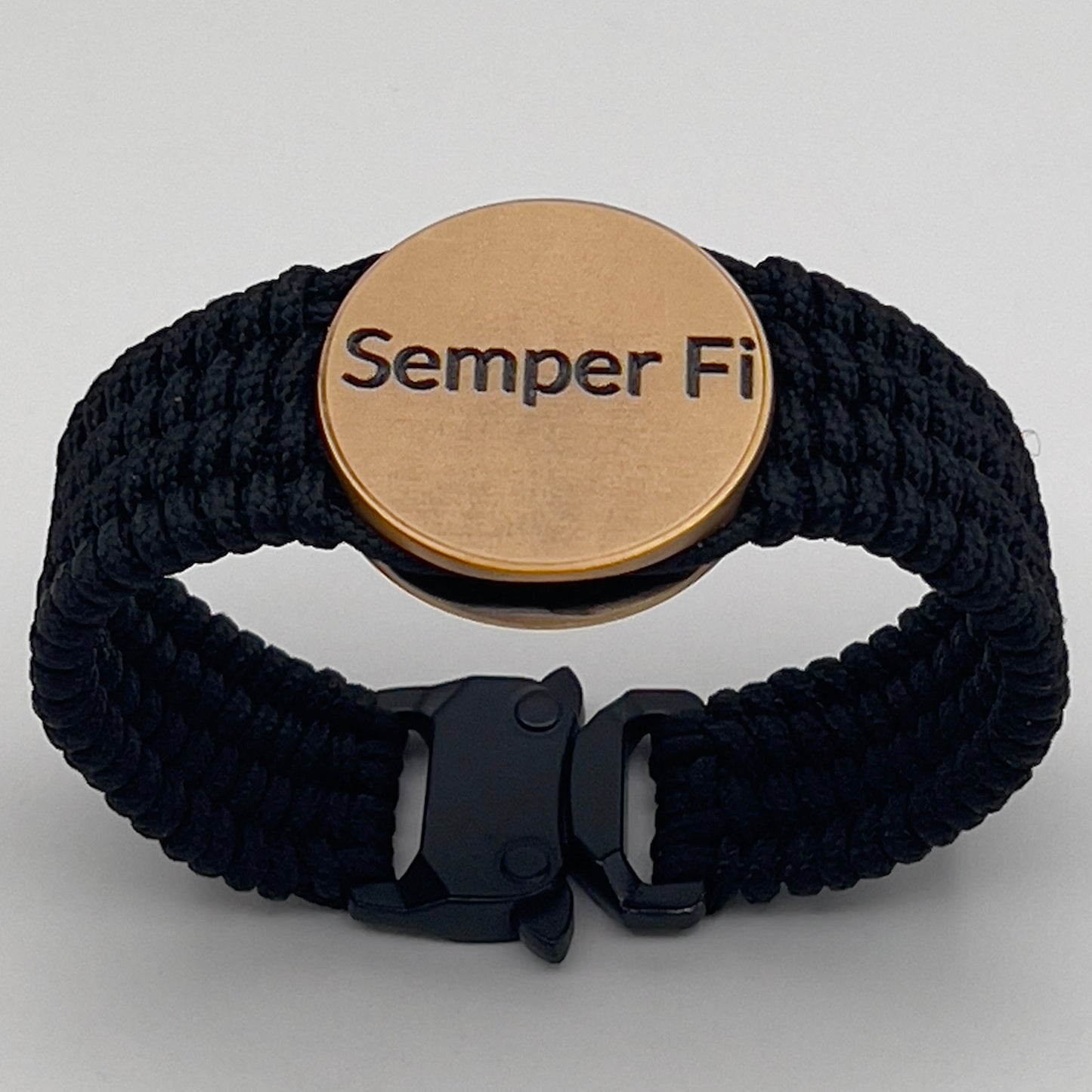 Thin, narrow, very flexible and comfortable braided United States Marine Corps bracelet featuring a 24K antique gold plated USMC Eagle Globe and Anchor medallion, a black Cobra style tactical buckle and woven with black Type-1 paracord.