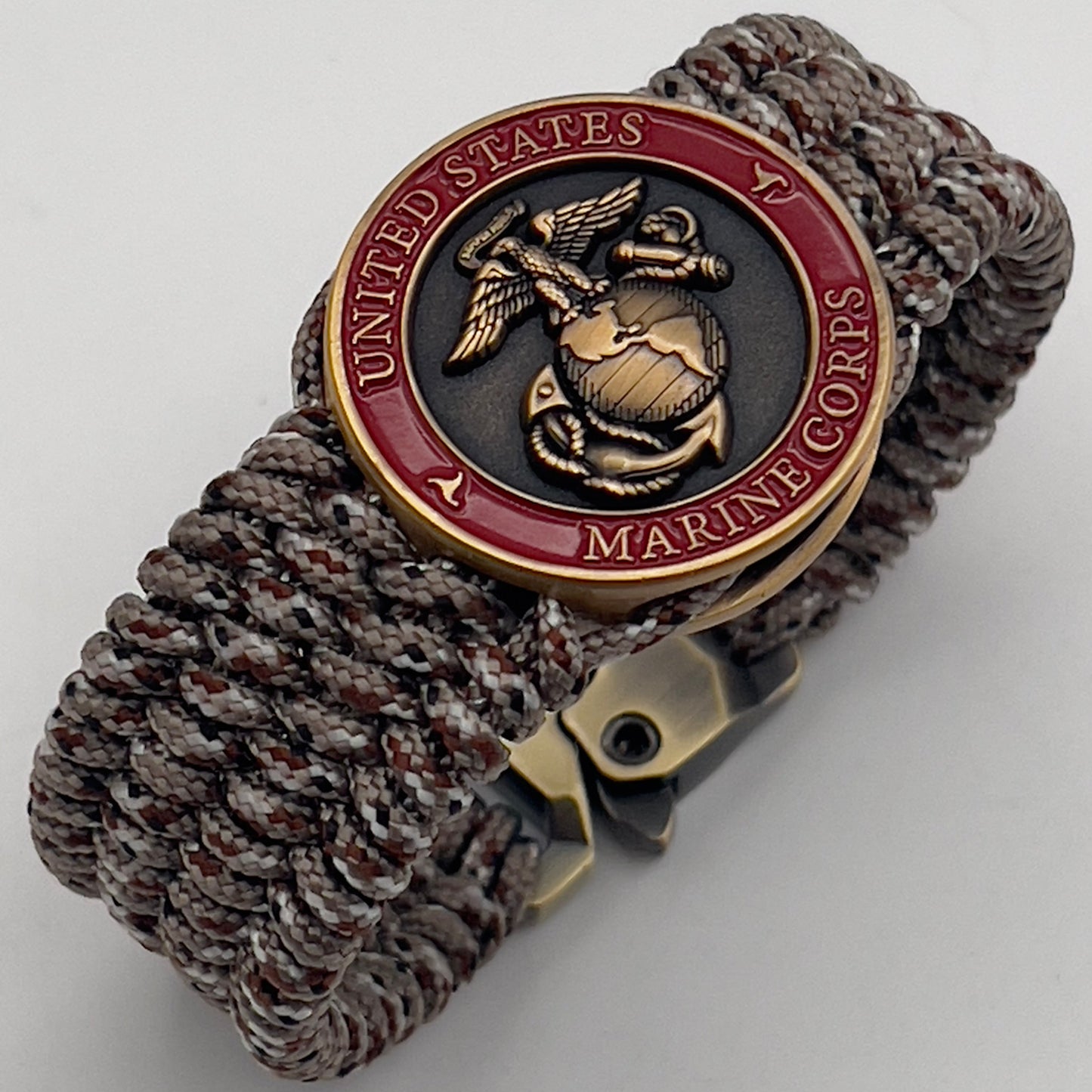 Thin, wide, very flexible and comfortable braided United States Marine Corps bracelet featuring a 24K antique gold plated USMC Eagle Globe and Anchor medallion engraved with the Punisher logo, a gold Cobra style tactical buckle and woven with Desert Camo Type-1 paracord.