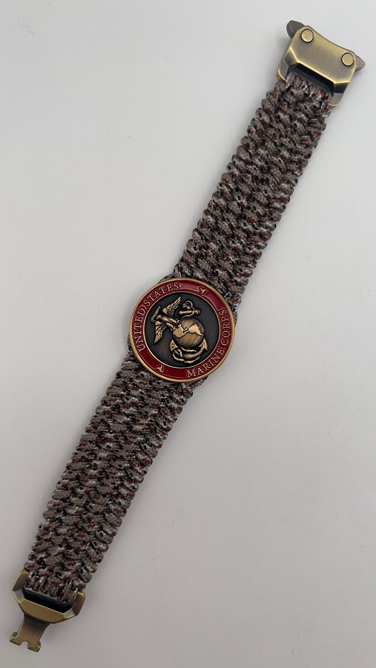 Thin, wide, very flexible and comfortable braided United States Marine Corps bracelet featuring a 24K antique gold plated USMC Eagle Globe and Anchor medallion engraved with the Punisher logo, a gold Cobra style tactical buckle and woven with Desert Camo Type-1 paracord.