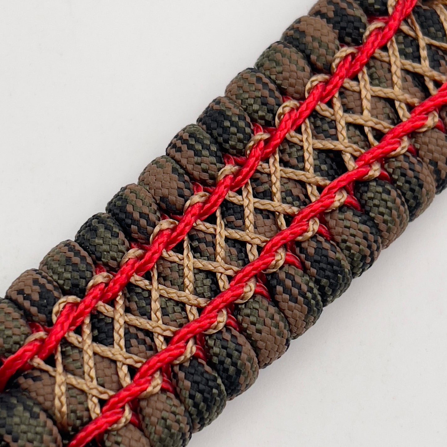 Thick, wide, rigid and comfortable braided United States Marine Corps bracelet featuring a 24K gold plated USMC Eagle Globe and Anchor medallion, a gold Cobra style tactical buckle and woven with Woodland Camo 550 paracord and Imperial Red micro and gold nano cord.