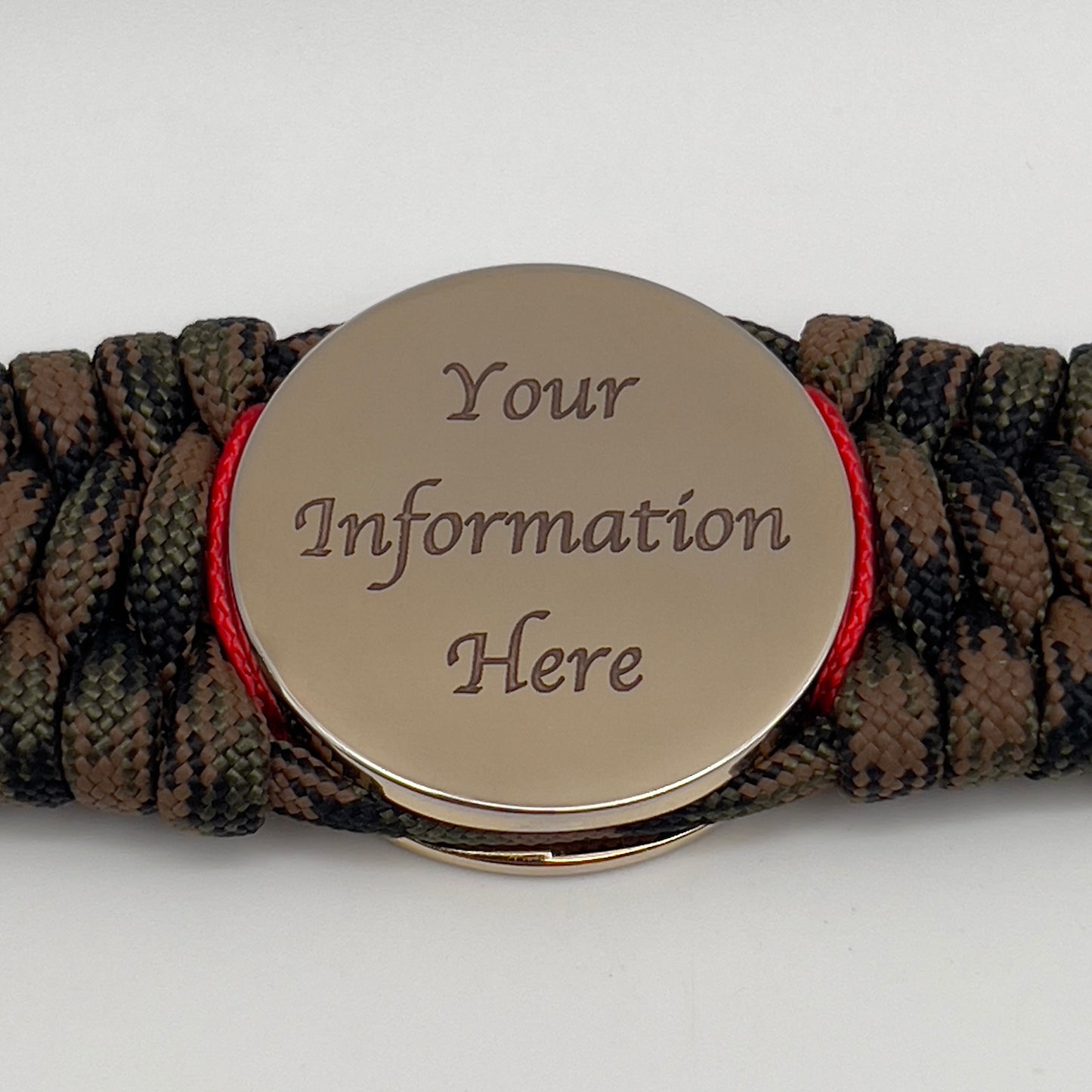 Thick, wide, rigid and comfortable braided United States Marine Corps bracelet featuring a 24K gold plated USMC Eagle Globe and Anchor medallion, a gold Cobra style tactical buckle and woven with Woodland Camo 550 paracord and Imperial Red micro and gold nano cord.