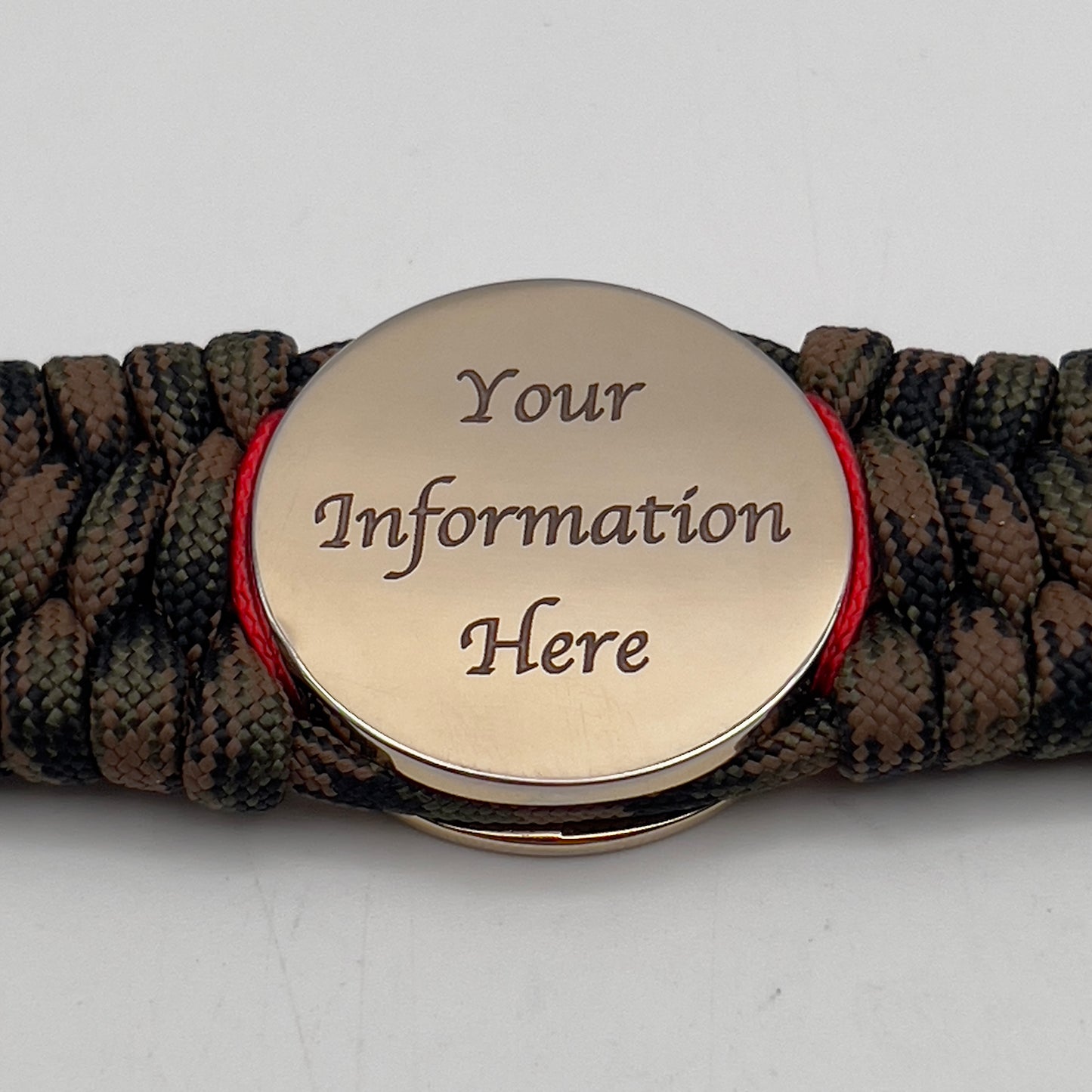 Thick, wide, rigid and comfortable braided United States Marine Corps bracelet featuring a 24K gold plated USMC Eagle Globe and Anchor medallion, a gold Cobra style tactical buckle and woven with Woodland Camo 550 paracord and Imperial Red micro and black nano cord.
