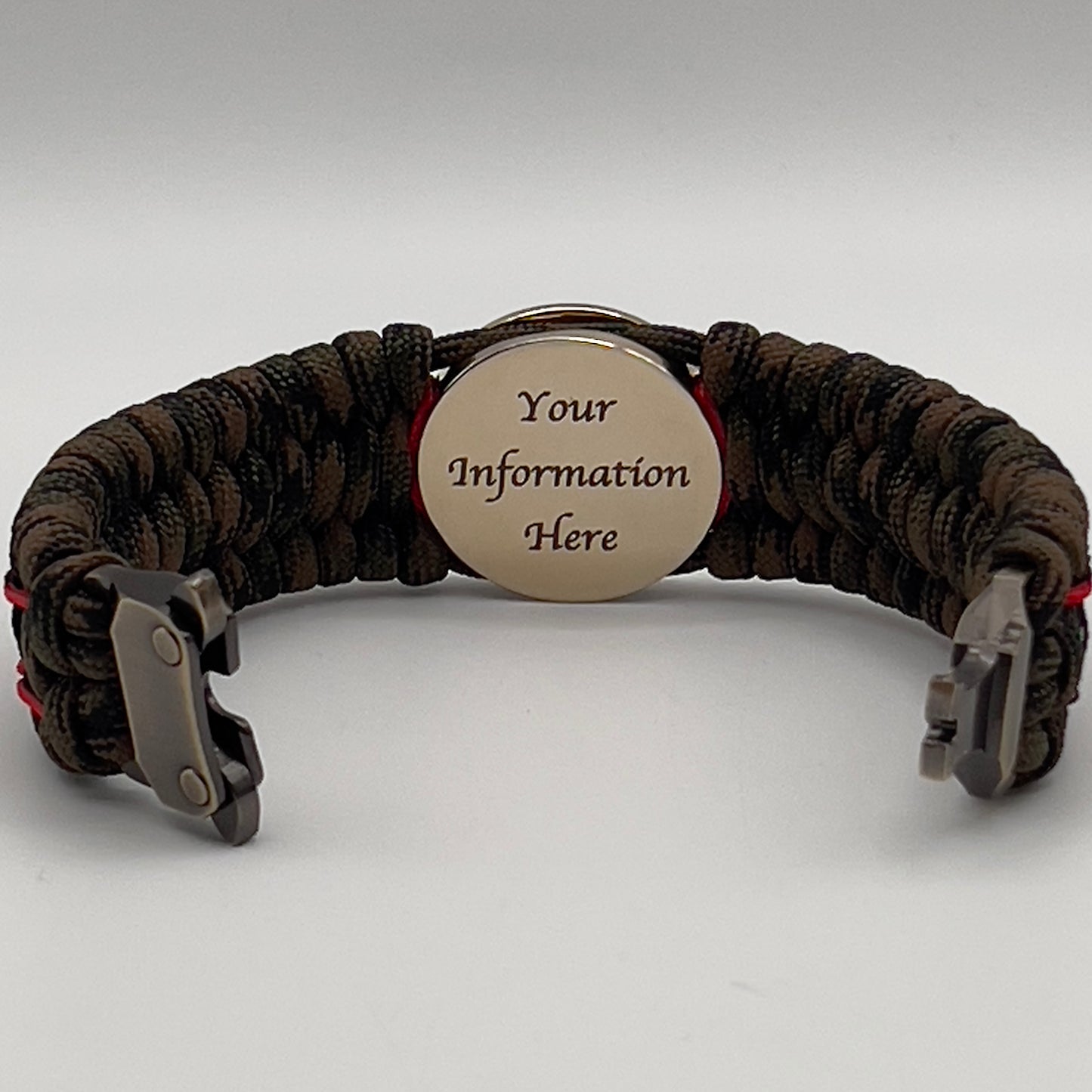 Thick, wide, rigid and comfortable braided United States Marine Corps bracelet featuring a 24K gold plated USMC Eagle Globe and Anchor medallion, a gold Cobra style tactical buckle and woven with Woodland Camo 550 paracord and Imperial Red micro and black nano cord.