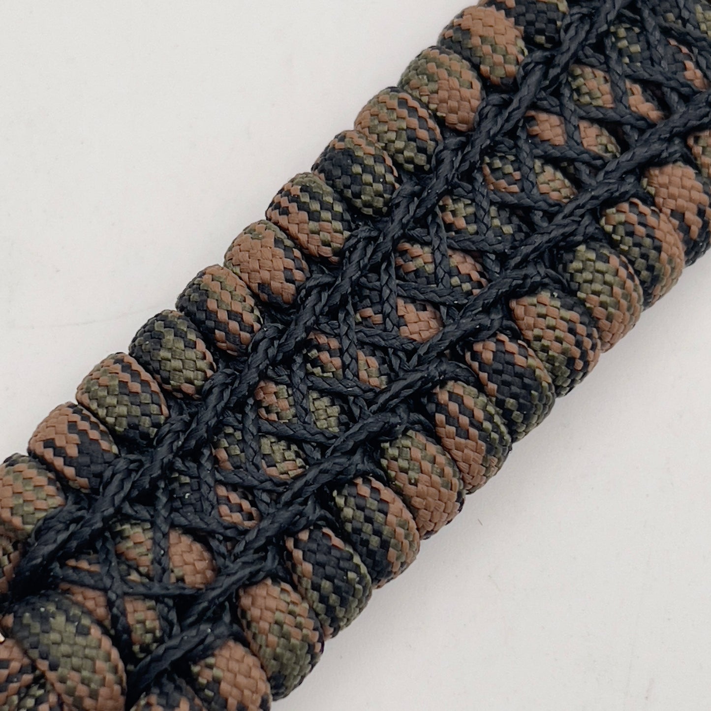 Thick, wide, rigid and comfortable braided United States Marine Corps bracelet featuring a 24K gold plated USMC Eagle Globe and Anchor medallion, a gold Cobra style tactical buckle and woven with Woodland Camo 550 paracord and black nano and micro cord.
