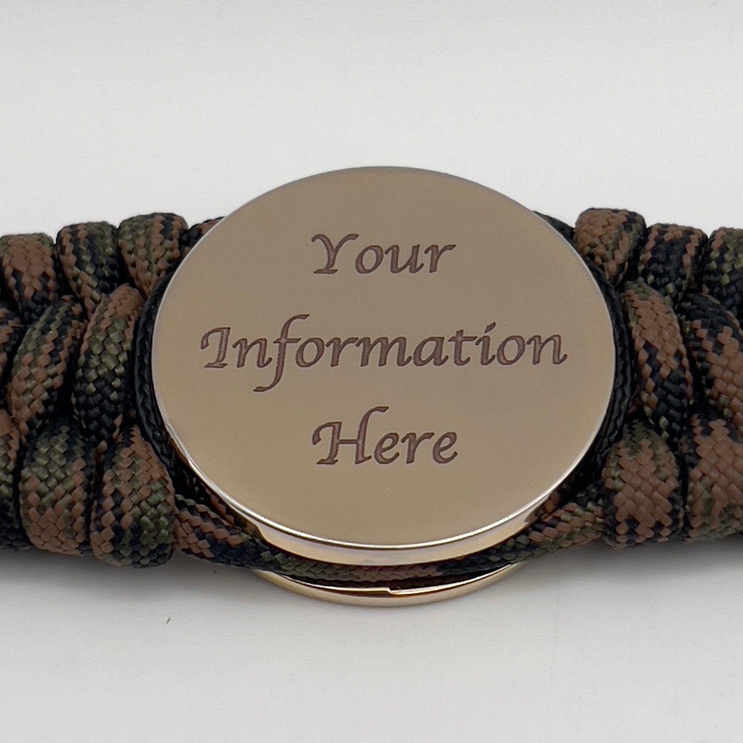 Thick, wide, rigid and comfortable braided United States Marine Corps bracelet featuring a 24K gold plated USMC Eagle Globe and Anchor medallion, a gold Cobra style tactical buckle and woven with Woodland Camo 550 paracord and black nano and micro cord.