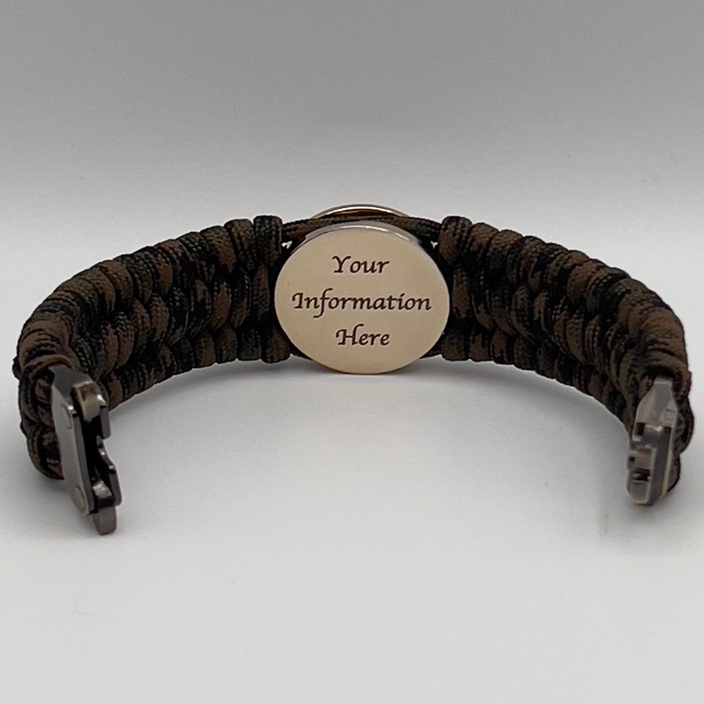 Thick, wide, rigid and comfortable braided United States Marine Corps bracelet featuring a 24K gold plated USMC Eagle Globe and Anchor medallion, a gold Cobra style tactical buckle and woven with Woodland Camo 550 paracord and black nano and micro cord.