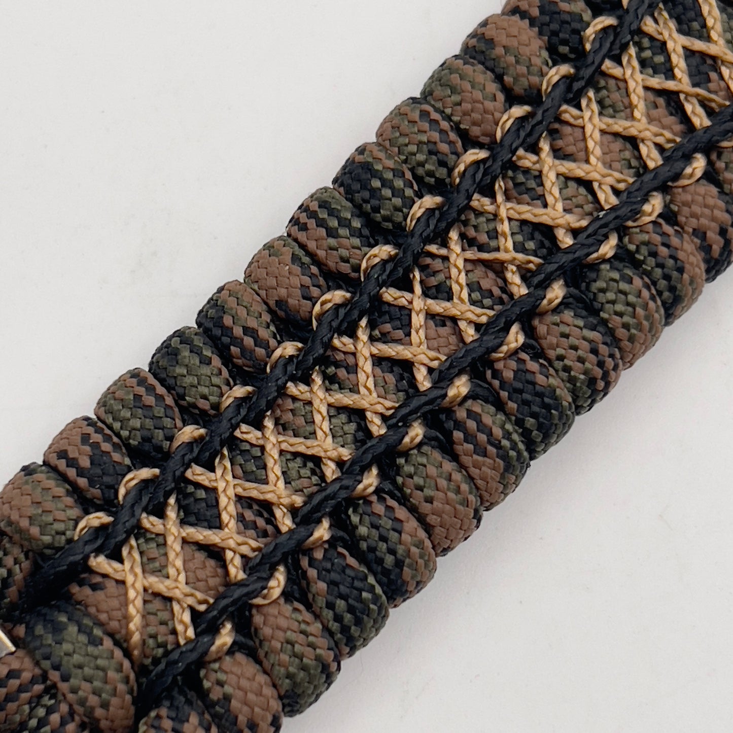 Thick, wide, rigid and comfortable braided United States Marine Corps bracelet featuring a 24K gold plated USMC Eagle Globe and Anchor medallion, a gold Cobra style tactical buckle and woven with Woodland 550 paracord, black micro and tan nano cord.