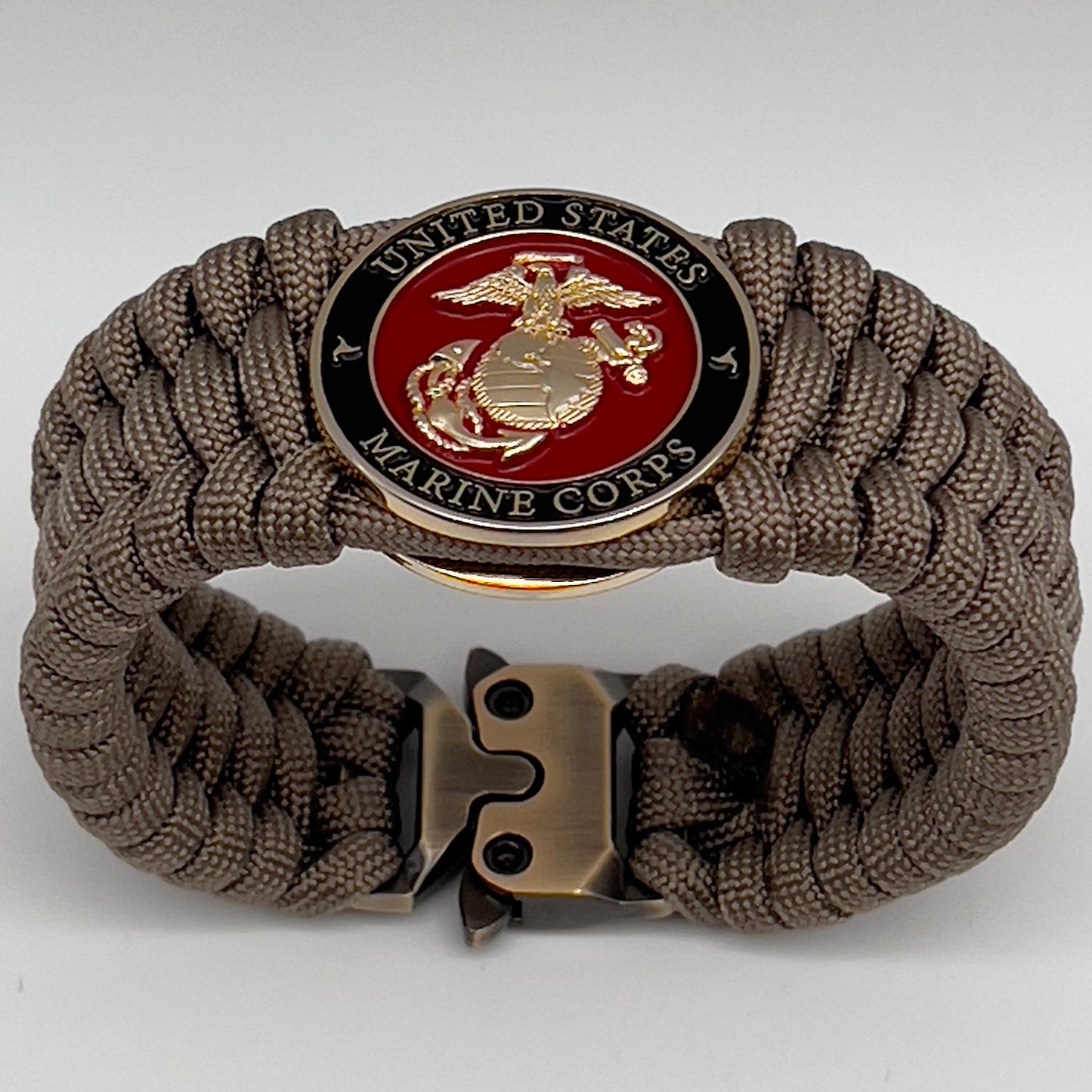 Thick, wide, semi-rigid and comfortable braided United States Marine Corps bracelet featuring a 24K gold plated USMC Eagle Globe and Anchor medallion, a gold Cobra style tactical buckle and woven with tan 550 paracord.