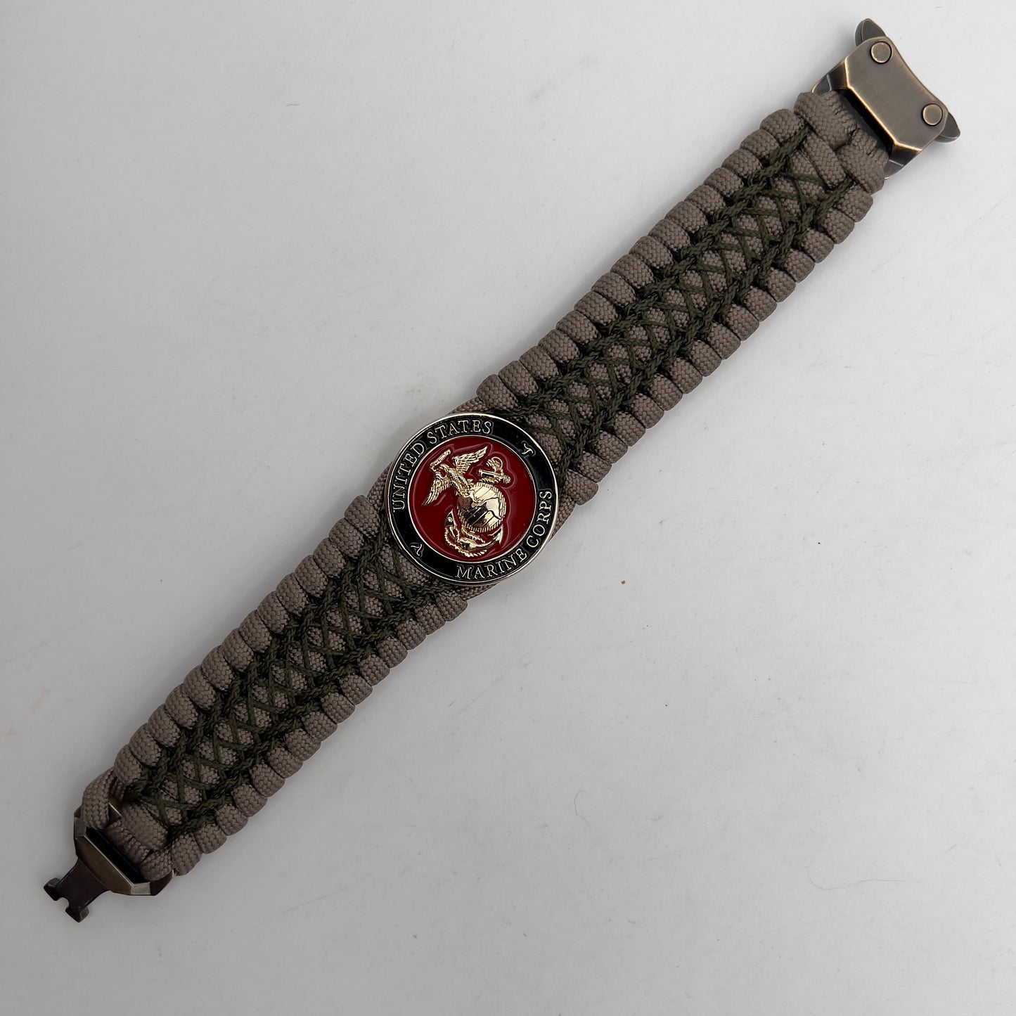 Thick, wide, rigid and comfortable braided United States Marine Corps bracelet featuring a 24K gold plated USMC Eagle Globe and Anchor medallion, a gold Cobra style tactical buckle and woven with tan 550 paracord and olive drab nano and micro cord.