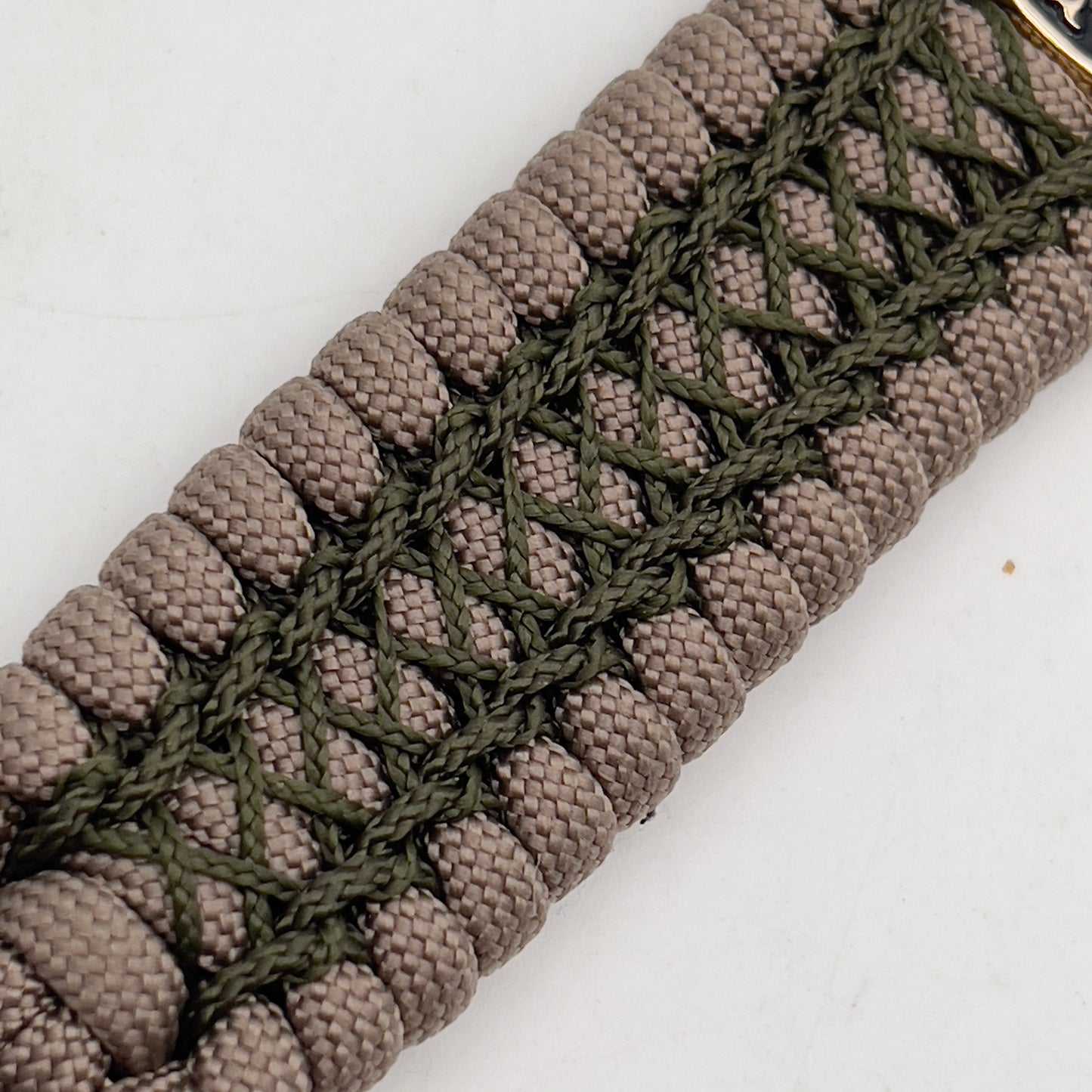 Thick, wide, rigid and comfortable braided United States Marine Corps bracelet featuring a 24K gold plated USMC Eagle Globe and Anchor medallion, a gold Cobra style tactical buckle and woven with tan 550 paracord and olive drab nano and micro cord.
