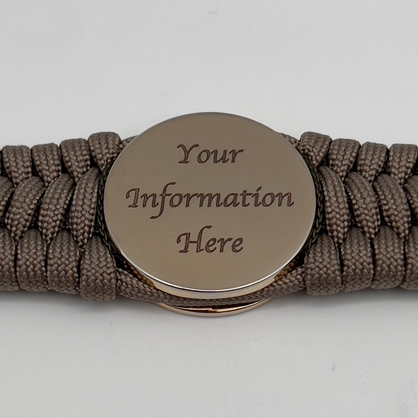 Thick, wide, rigid and comfortable braided United States Marine Corps bracelet featuring a 24K gold plated USMC Eagle Globe and Anchor medallion, a gold Cobra style tactical buckle and woven with tan 550 paracord and olive drab nano and micro cord.