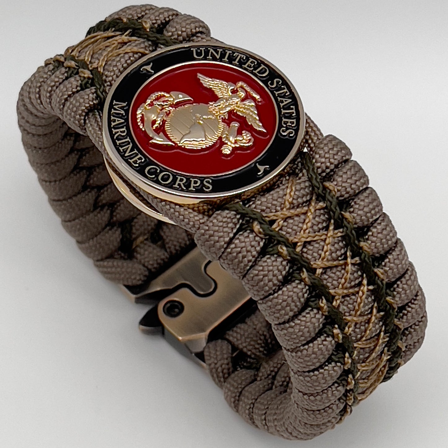 Thick, wide, rigid and comfortable braided United States Marine Corps bracelet featuring a 24K gold plated USMC Eagle Globe and Anchor medallion, a gold Cobra style tactical buckle and woven with tan 550 paracord and olive drab micro and tan nano cord.